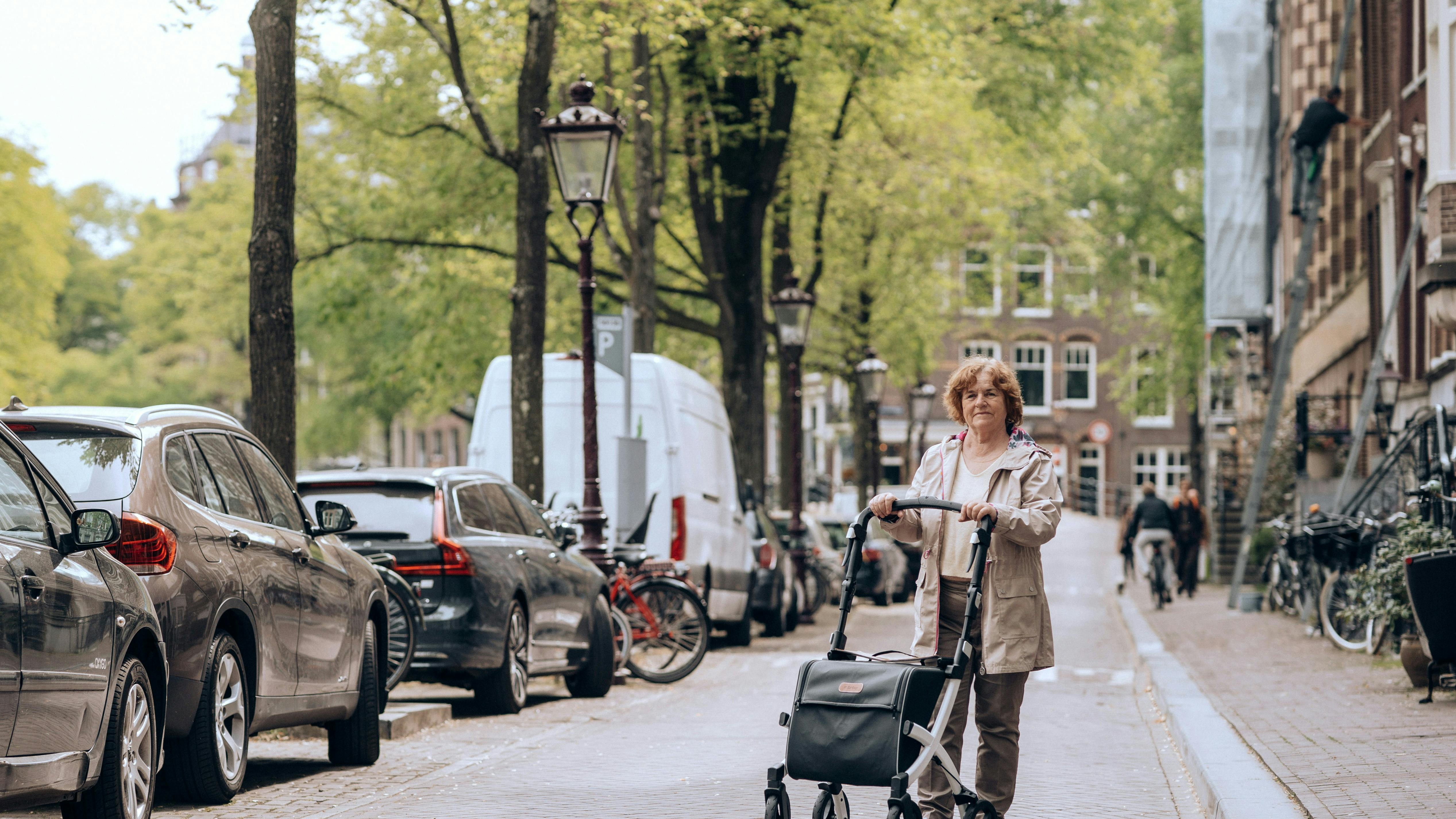 Ældre dame med særlig indkøbsvogn går tur