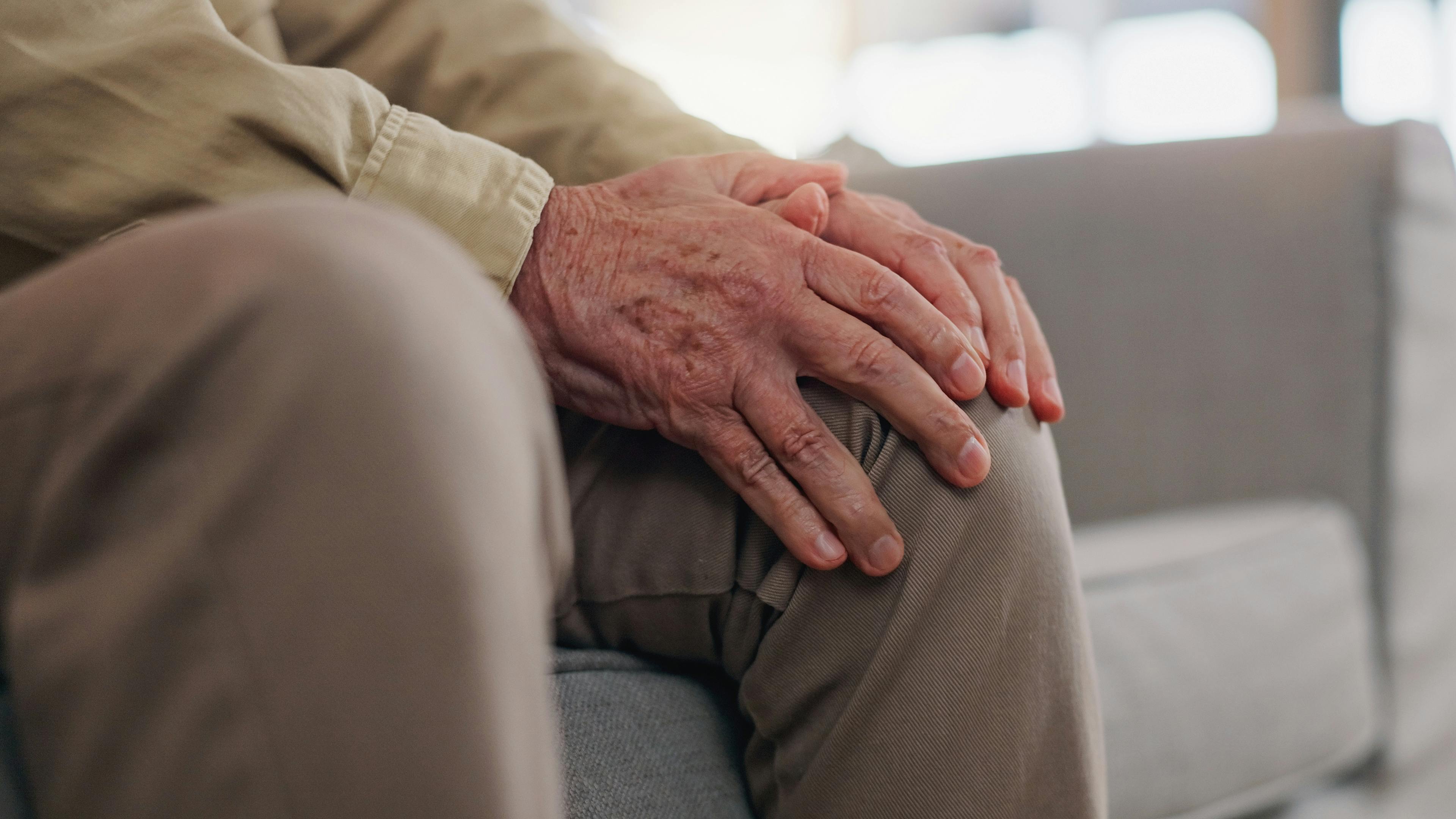 Ældre mand, der ømmer sig på knæet.