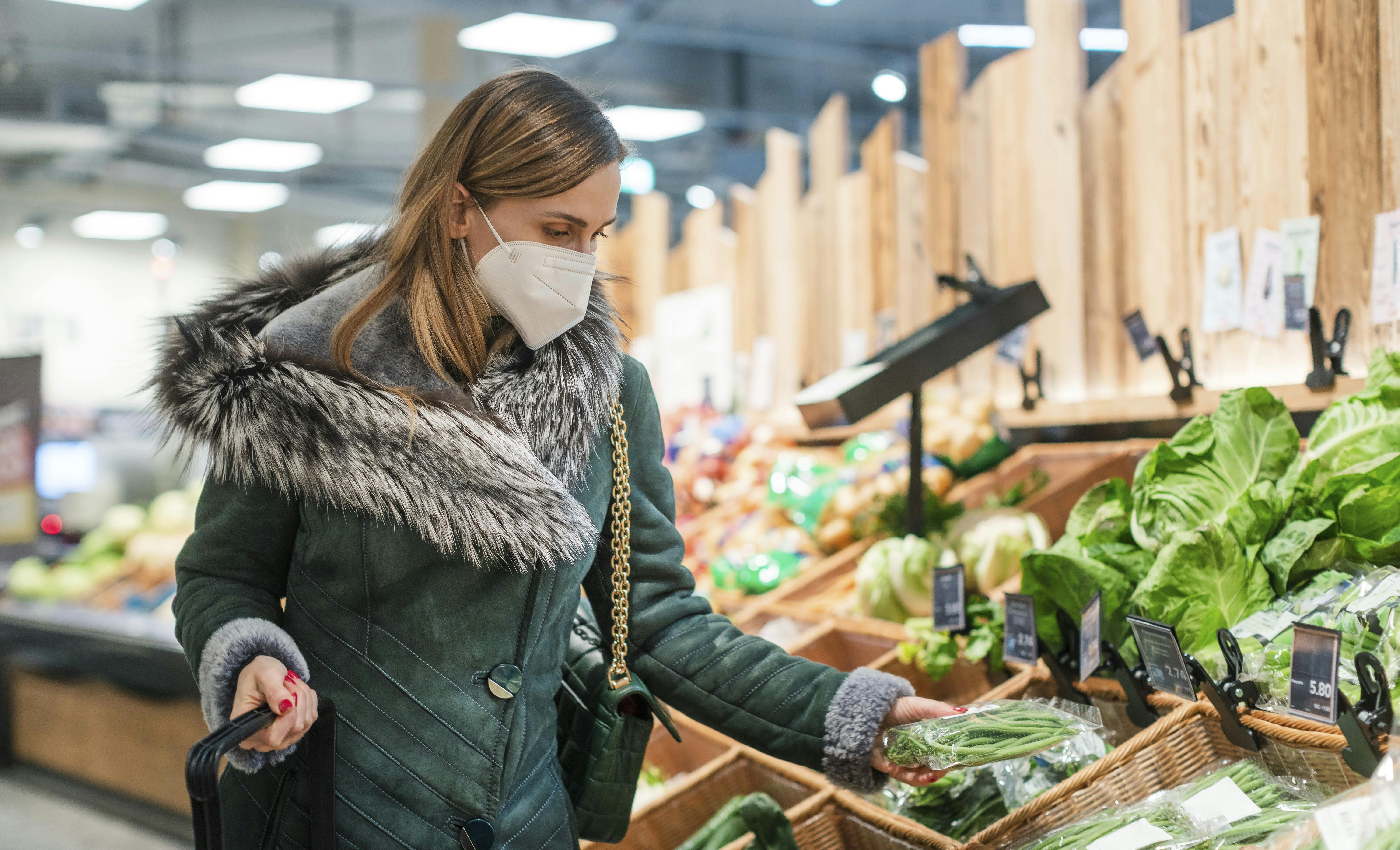 Woman wearing ffp2 face mask shopping groceries in supermarket