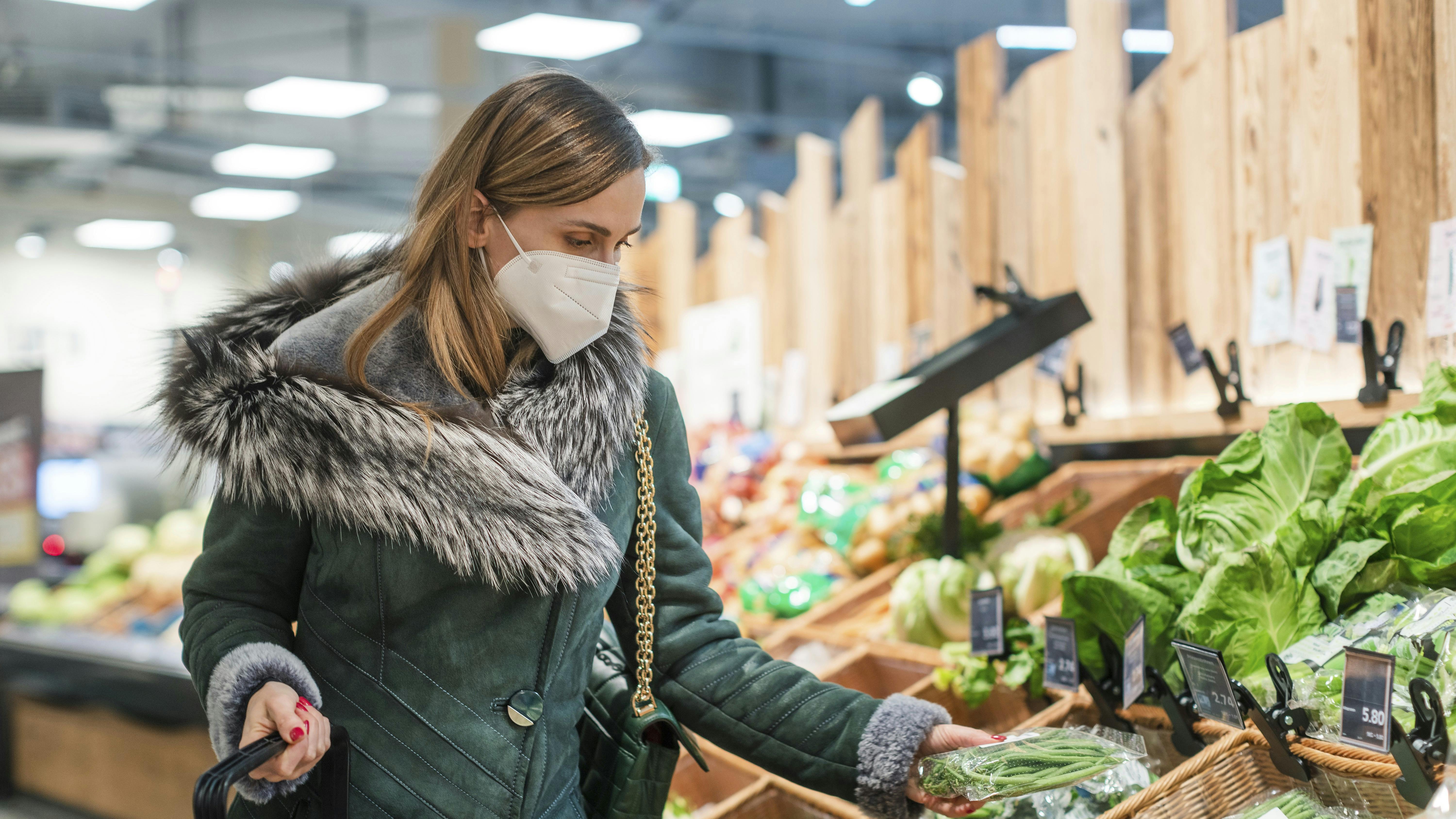Woman wearing ffp2 face mask shopping groceries in supermarket