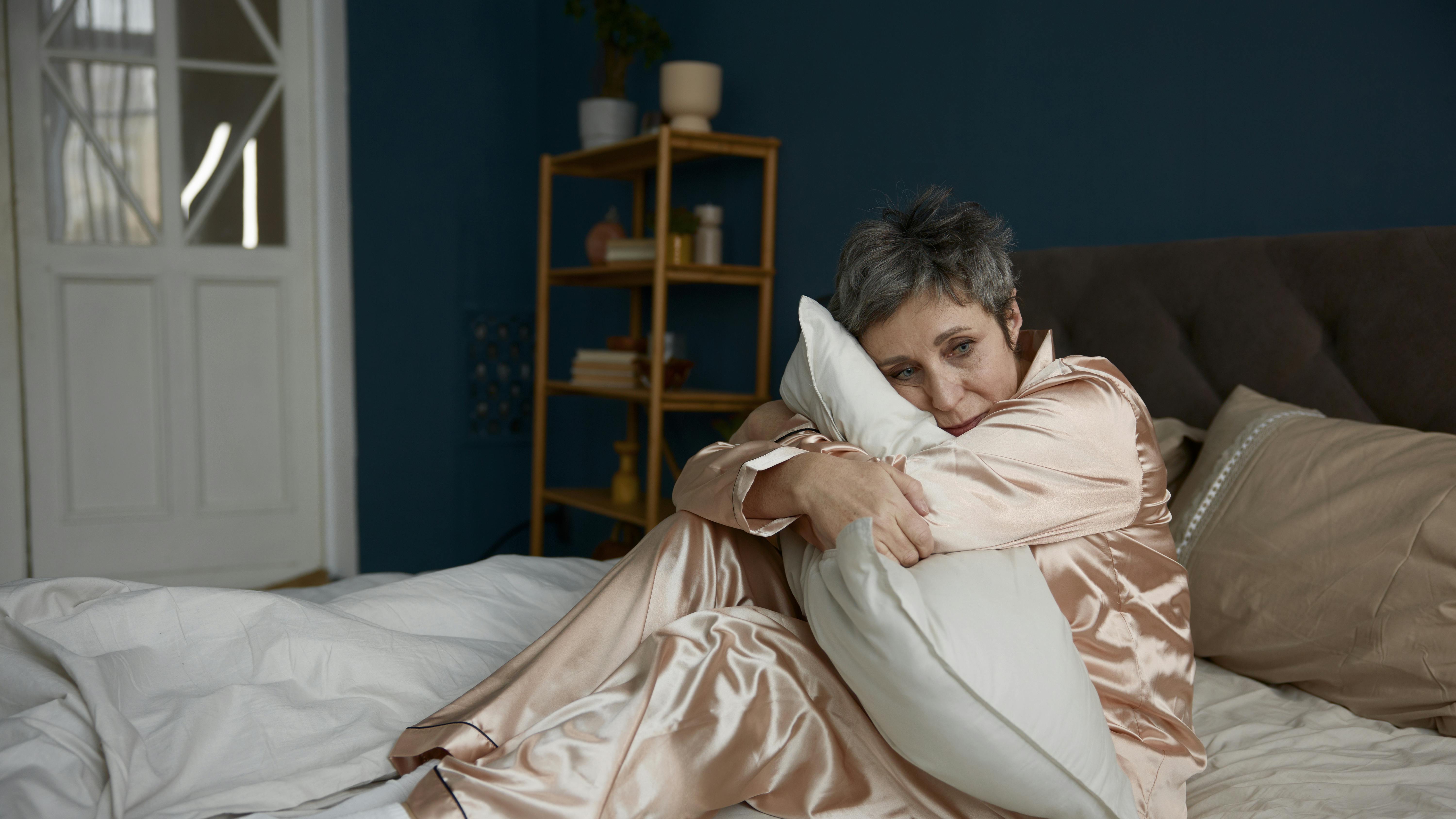 Kvinde i smerter i sin seng.