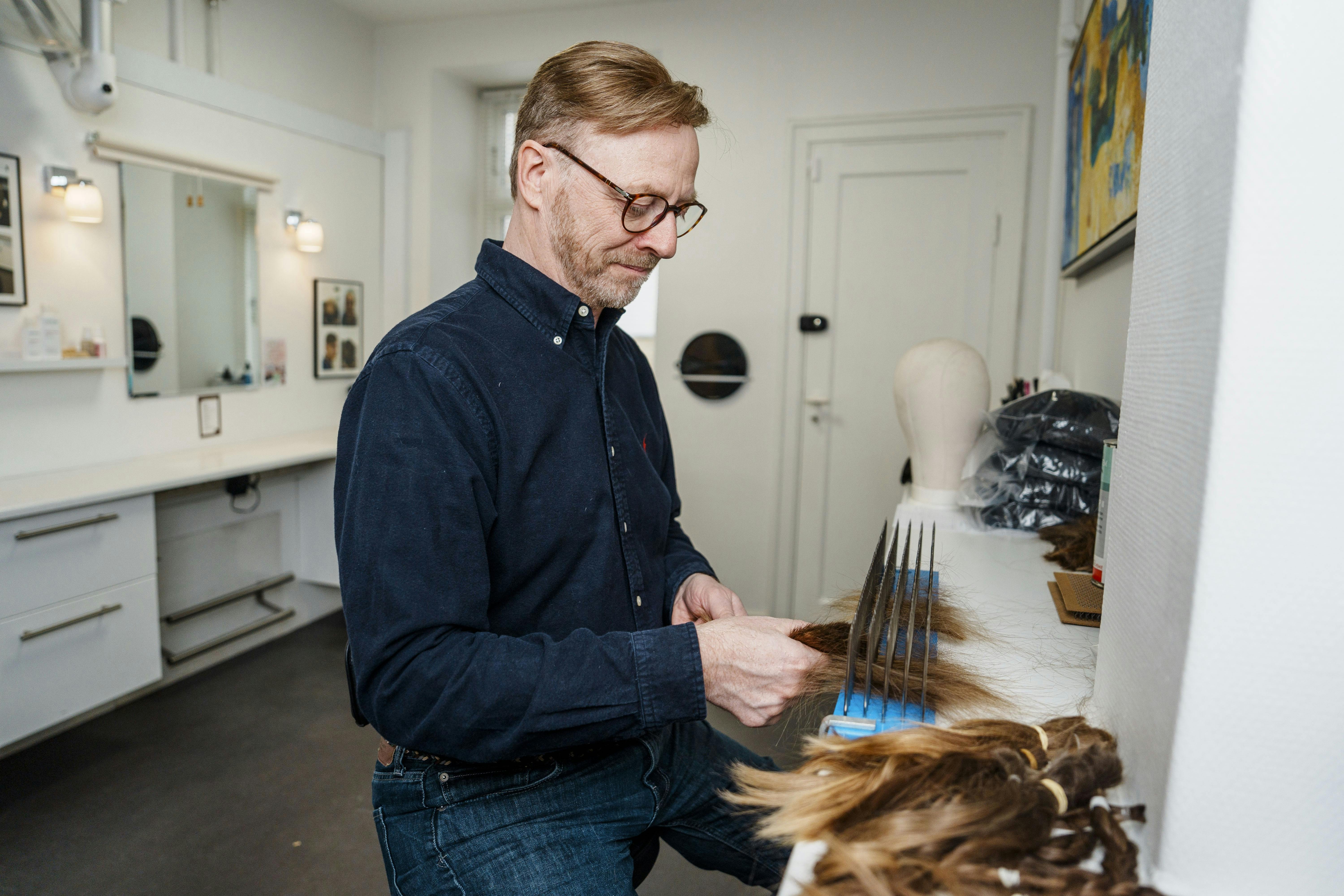 Claus begynder med at børste donationshåret igennem på en karte.