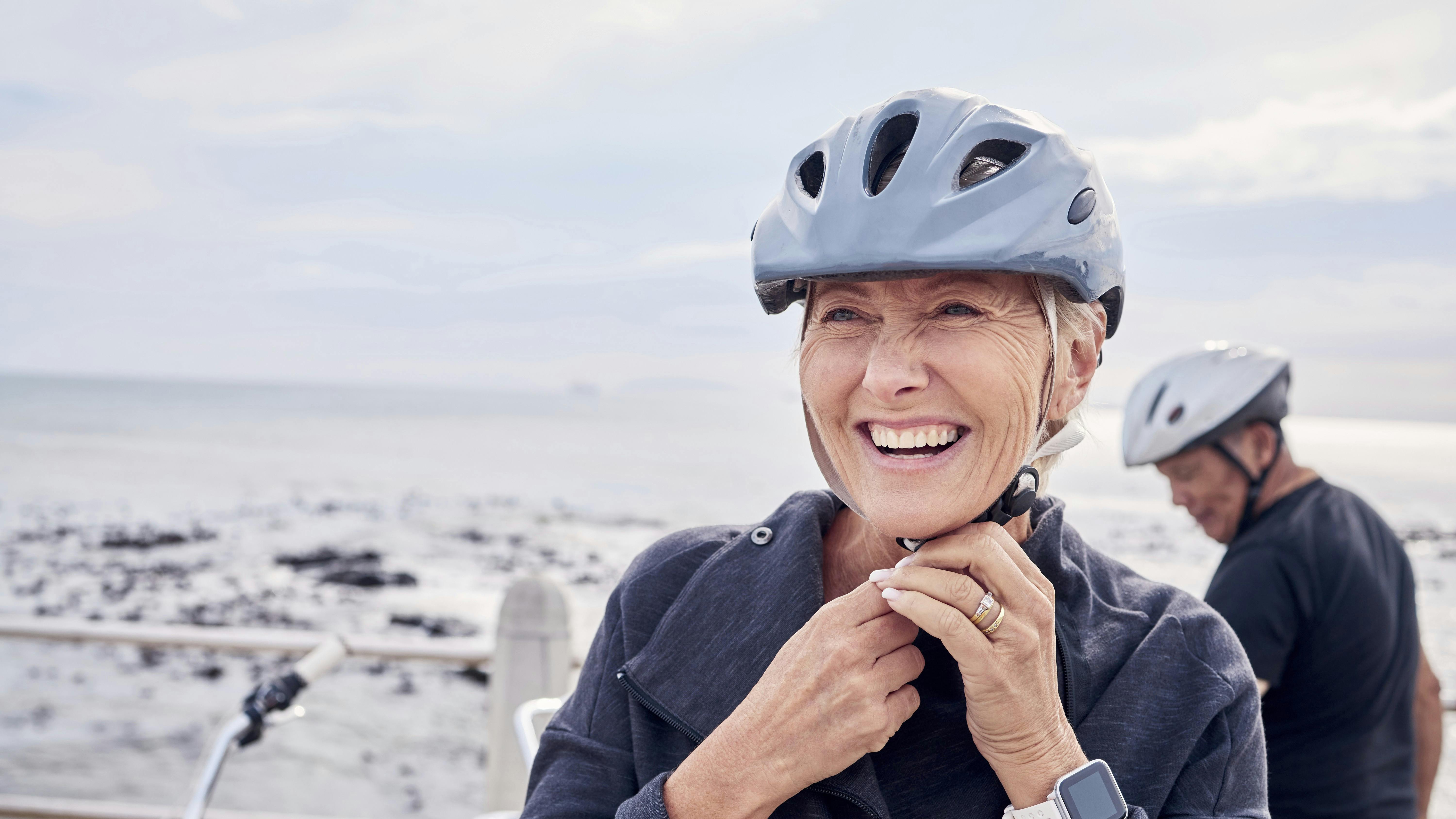 Moden kvinde ved cykel med cykelhjelm på