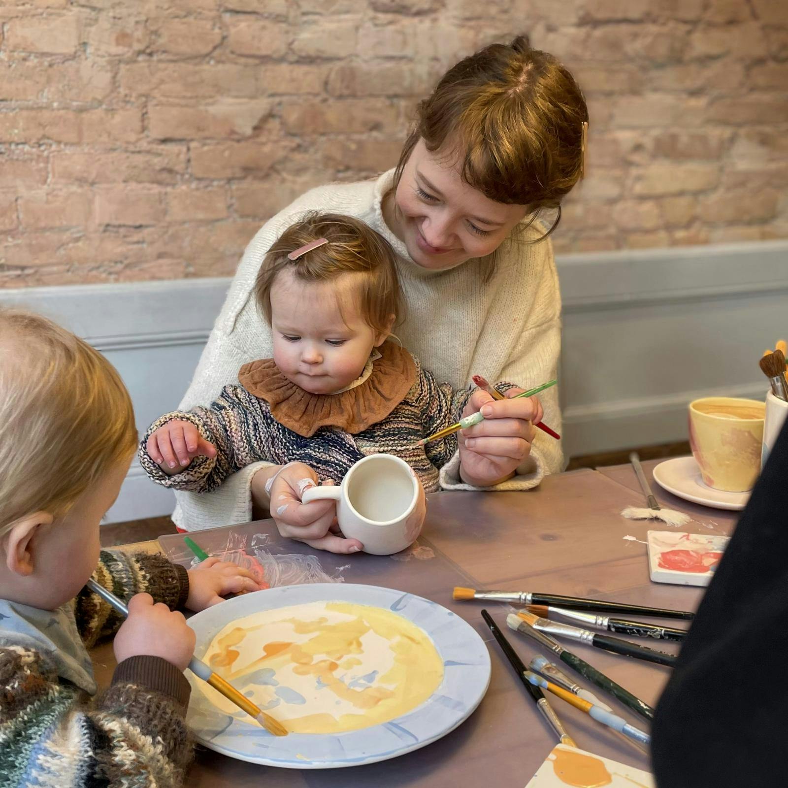 Mor og barn, der maler påskeæg.