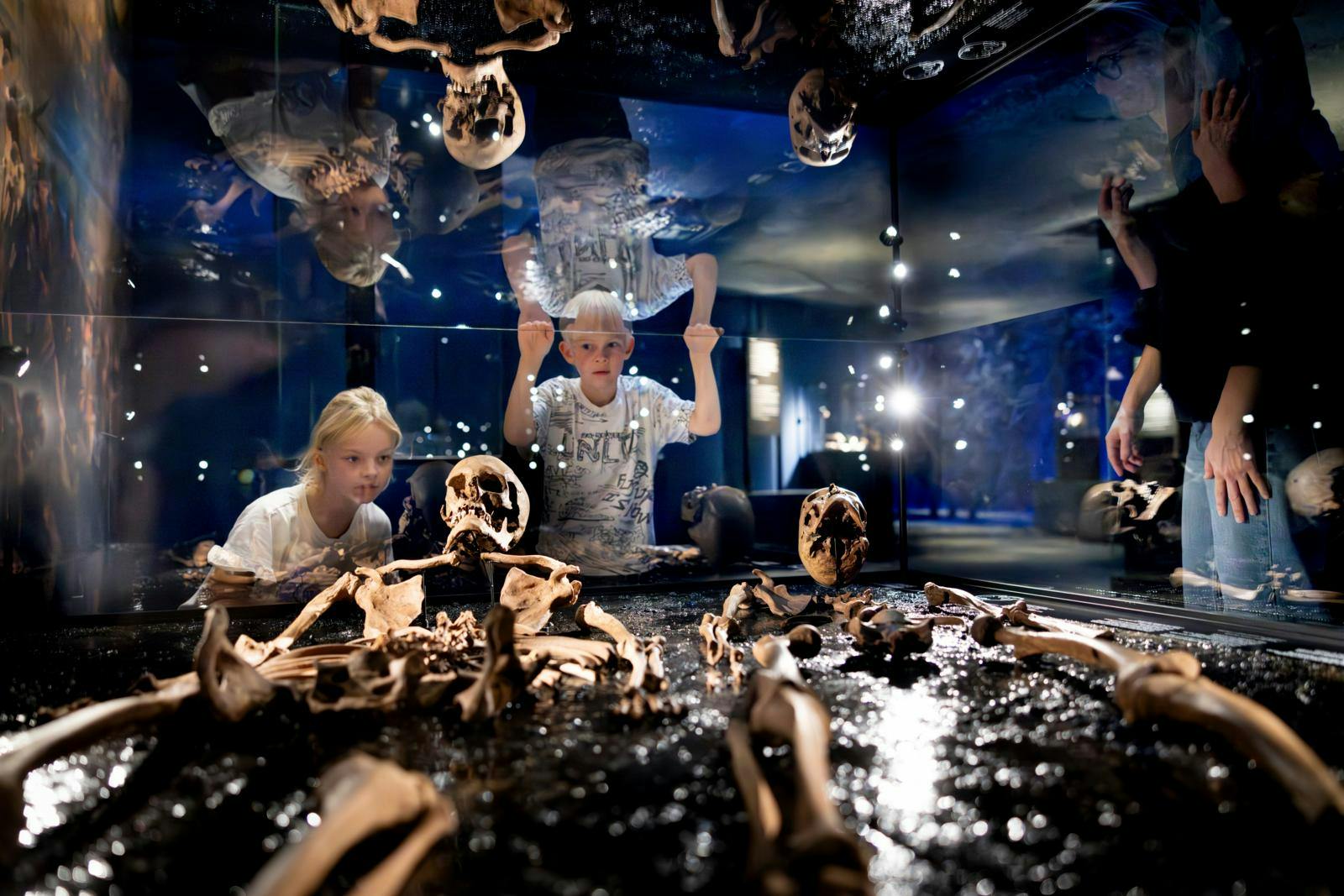 Børn der kigger på ting fra stenalderen på et museum.