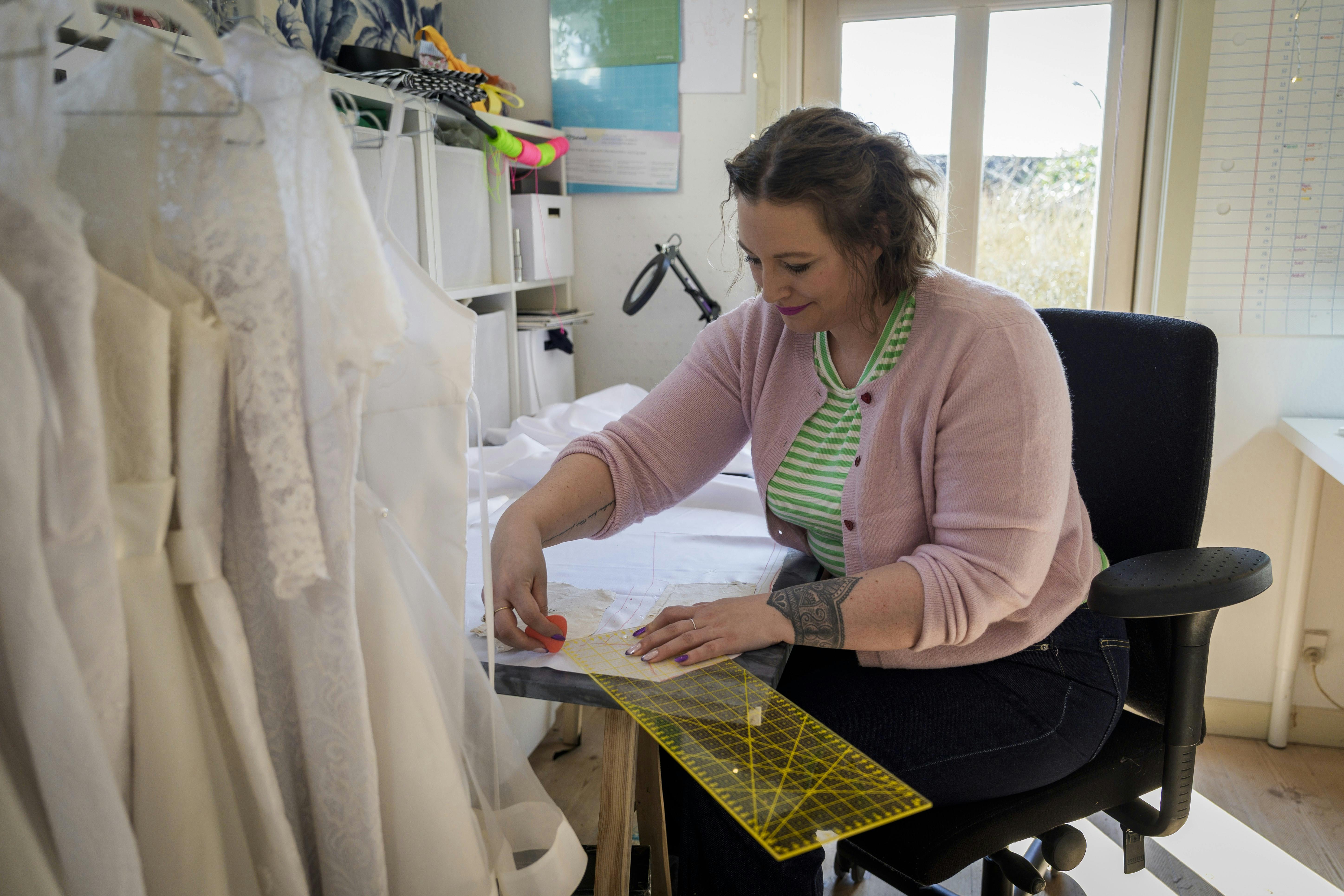 Nikoline Vestergaard måler, klipper og syr til den store guldmedalje i sit lille værksted ved navn Nikolines Systue.