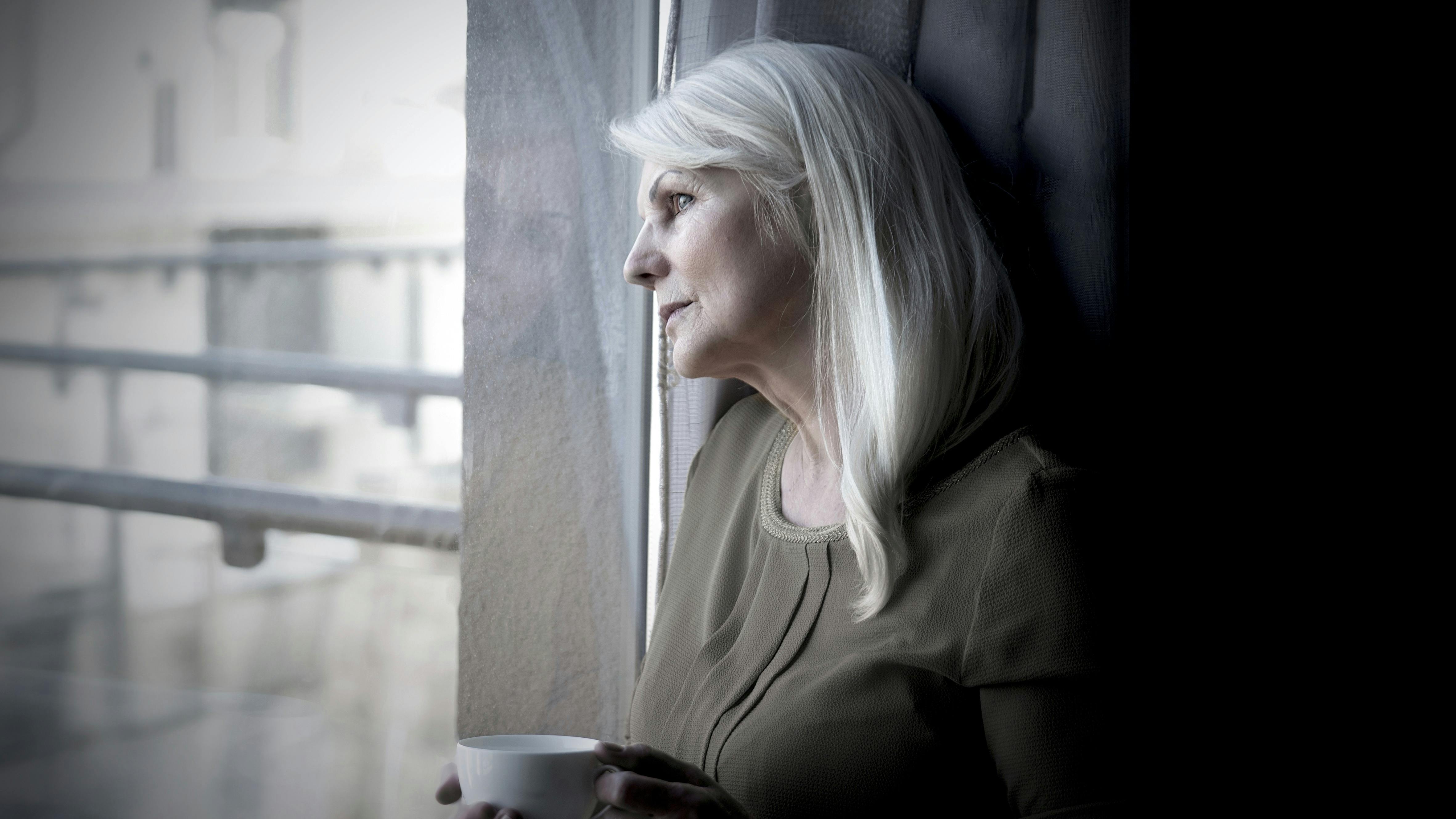 Trist kvinde kigger ud ad vinduet