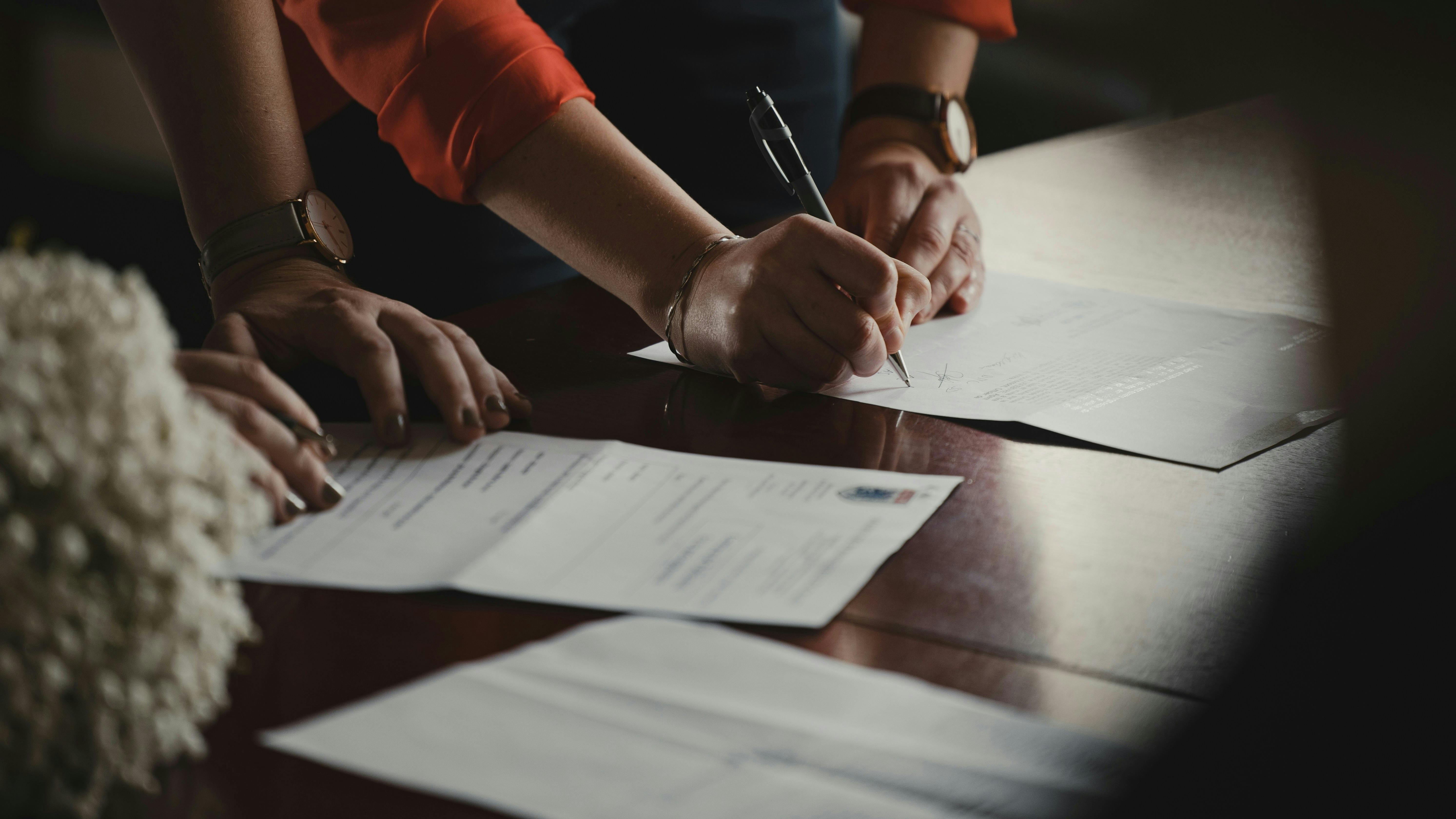 To personer, der underskriver papirer