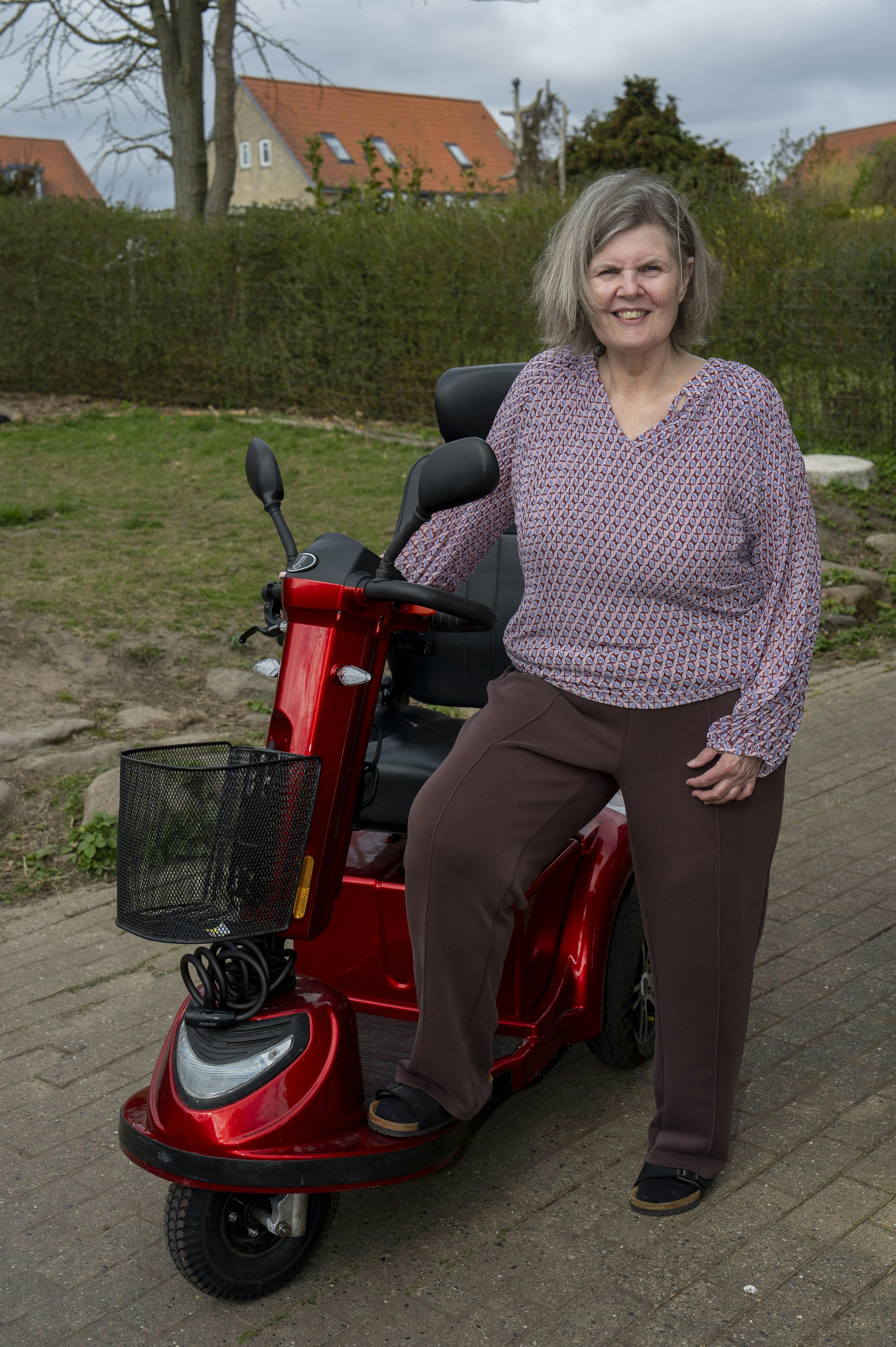 Tinda der står ved hendes elscooter. 