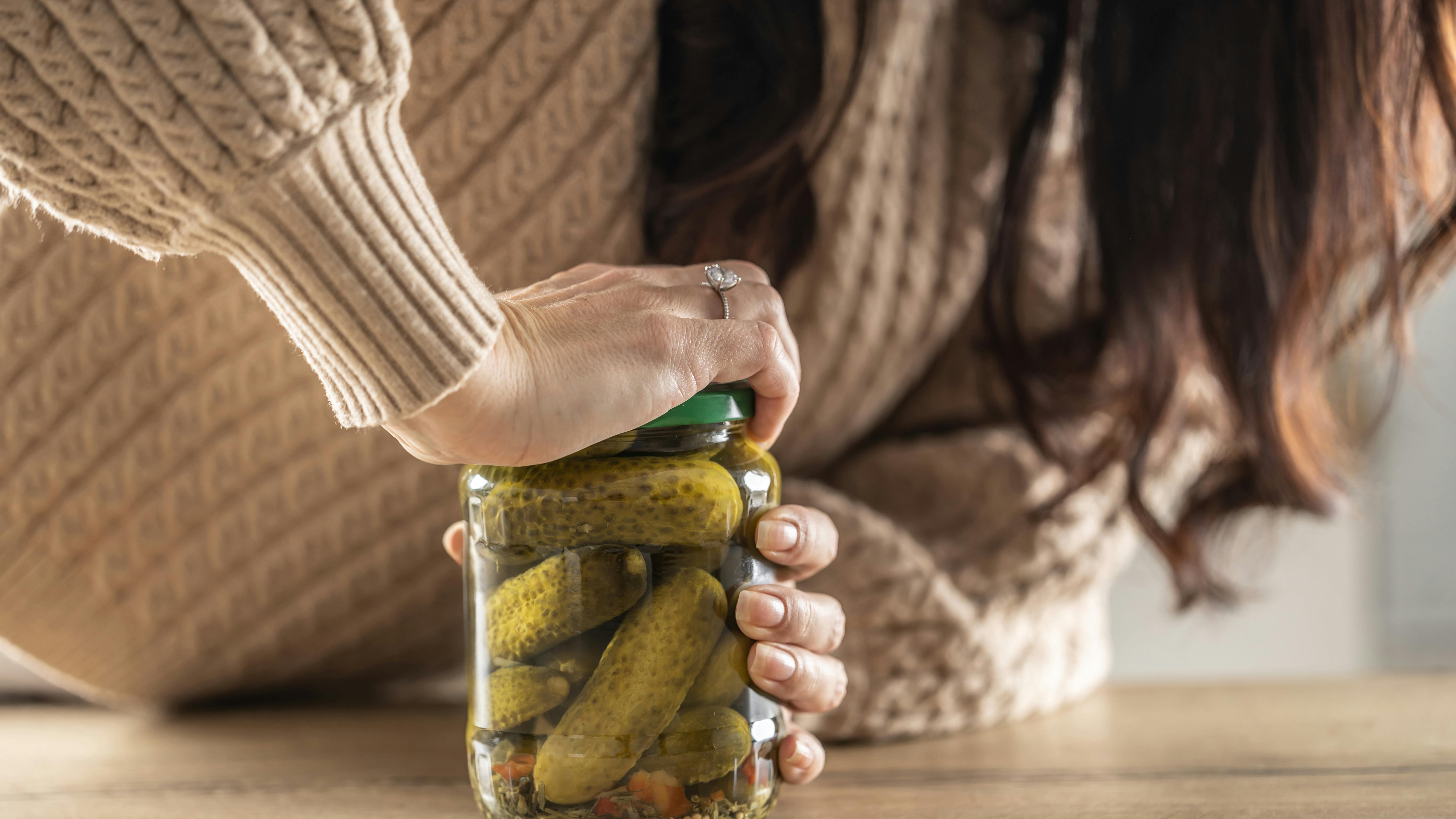 Kvinde prøver at åbne låg på glas