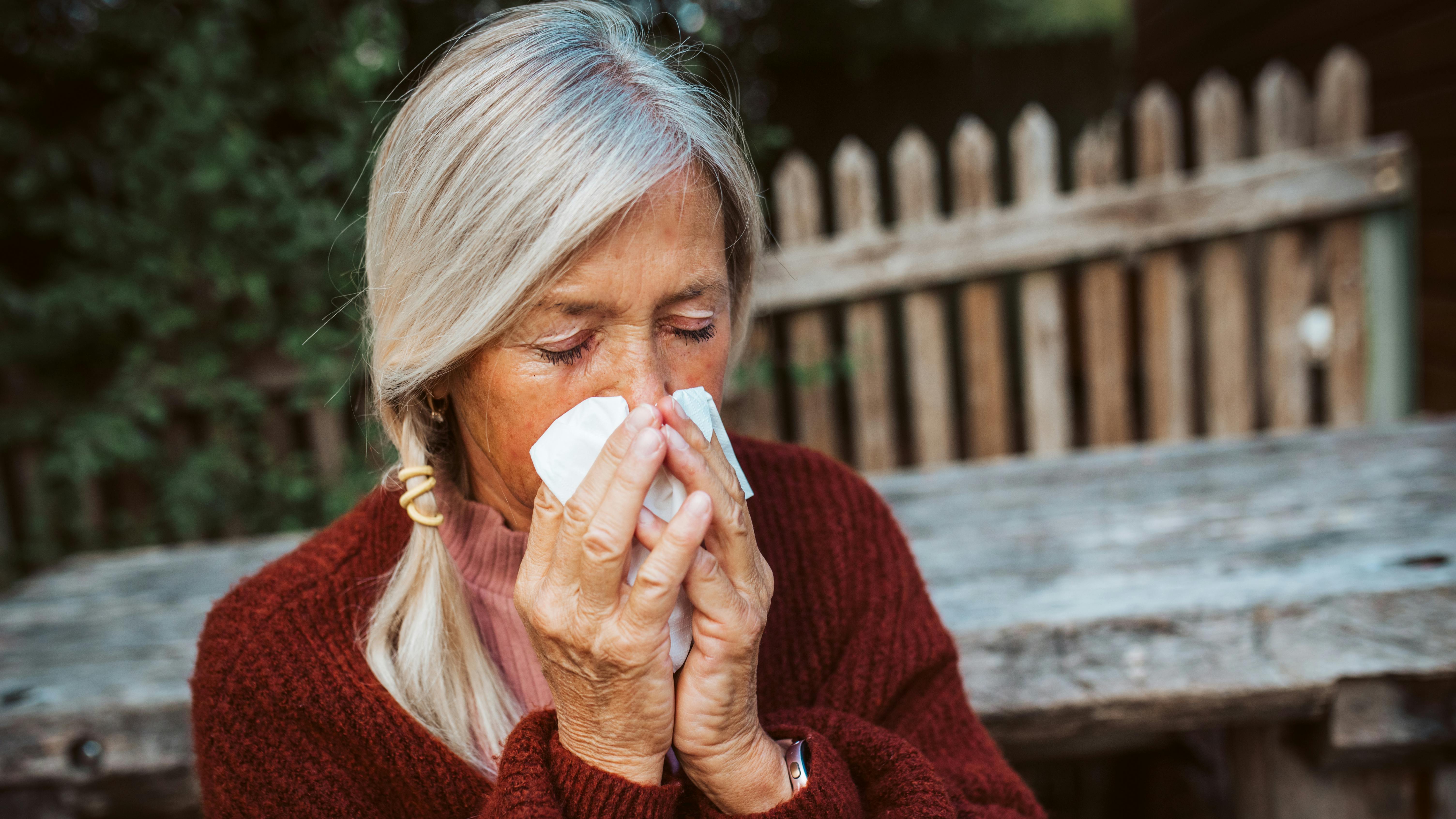 Ældre kvinde pudser næse