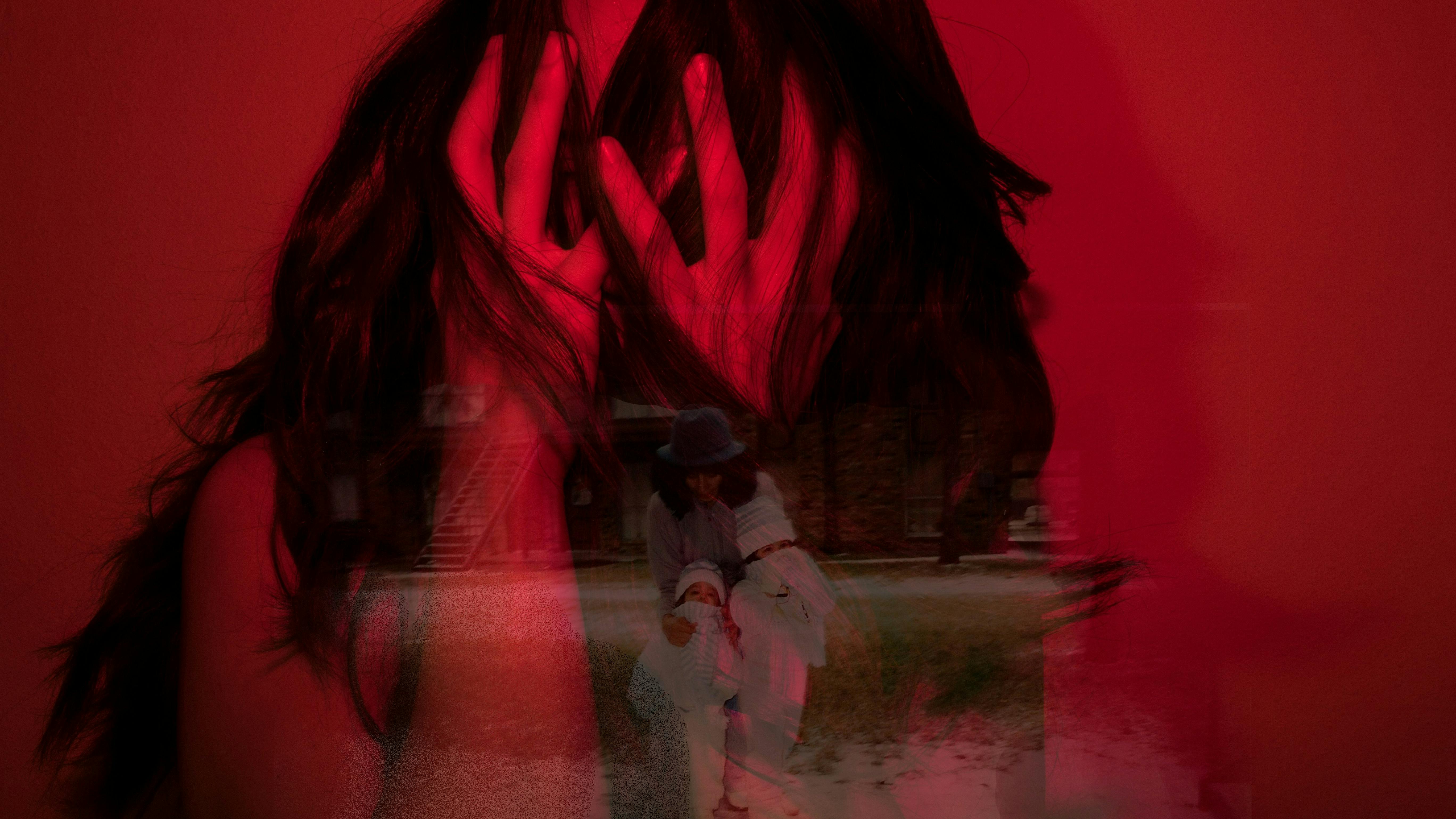 Kvinde, der har hænderne op foran ansigtet.