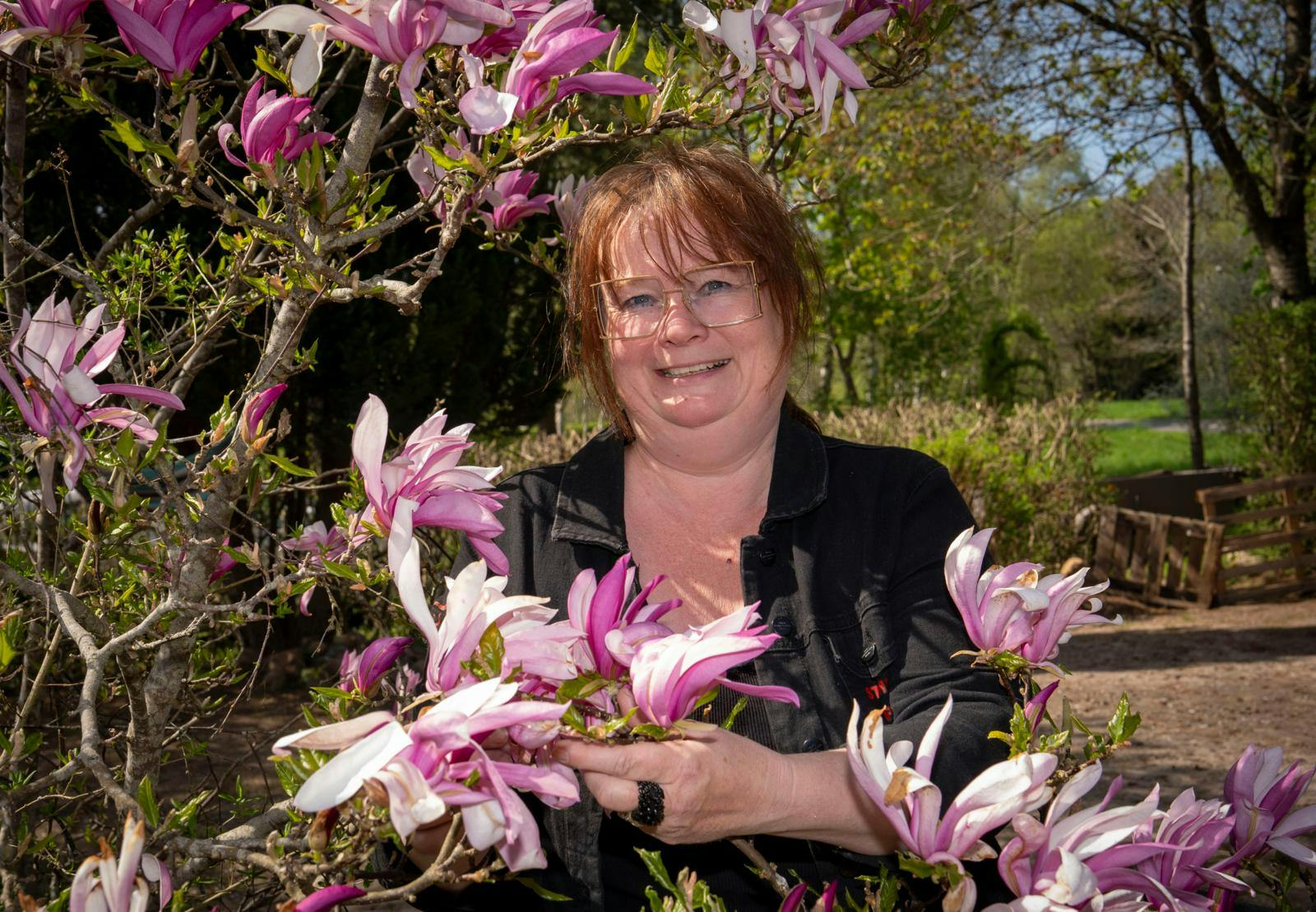 Kvinde omgivet af blomster.