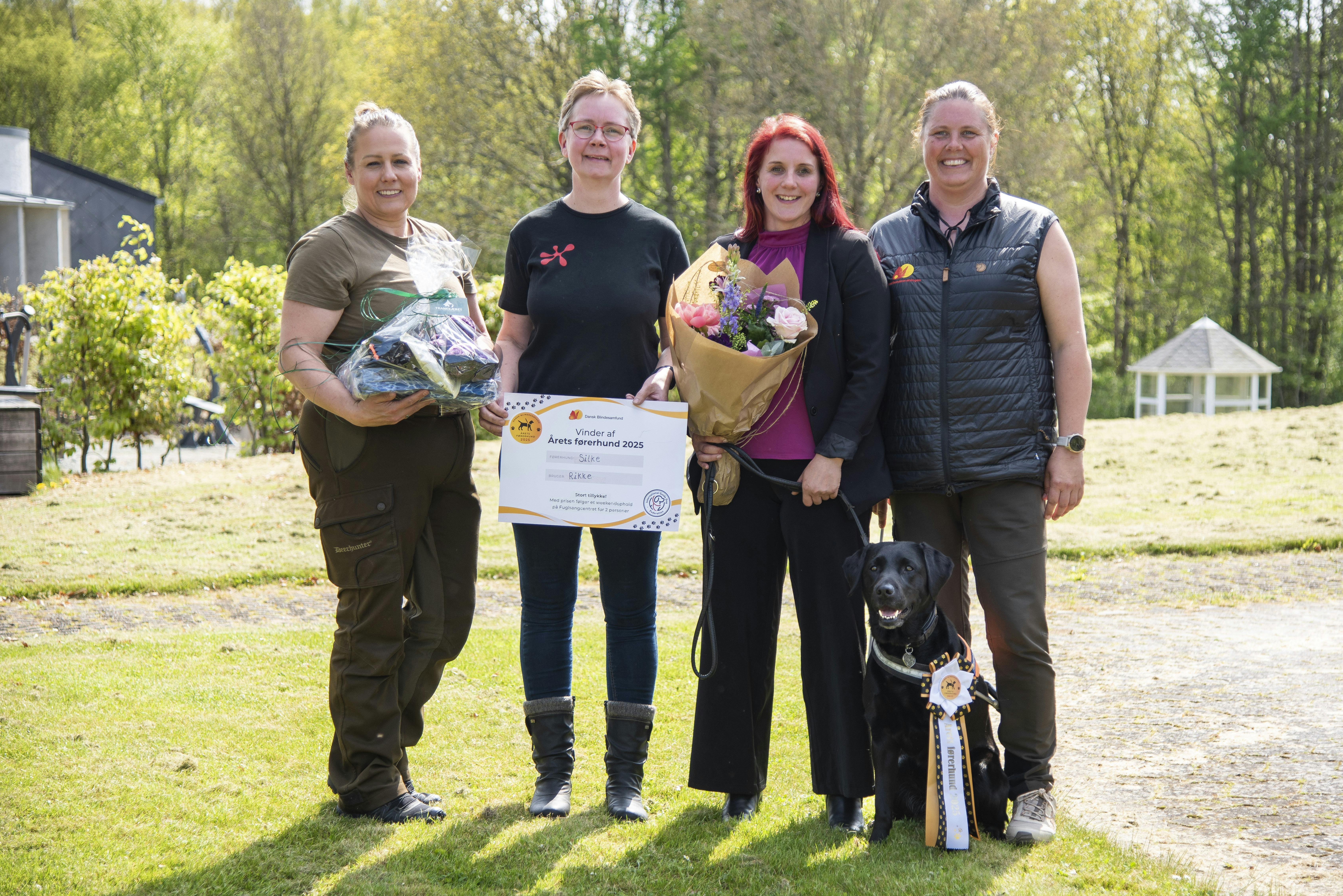 Rikke Hjortnæs med sin førerhund Silke ved sidstnævntes kåring som Årets Førerhund omgivet af Silkes fodervært, opdrætter og førerhundeinstruktør.