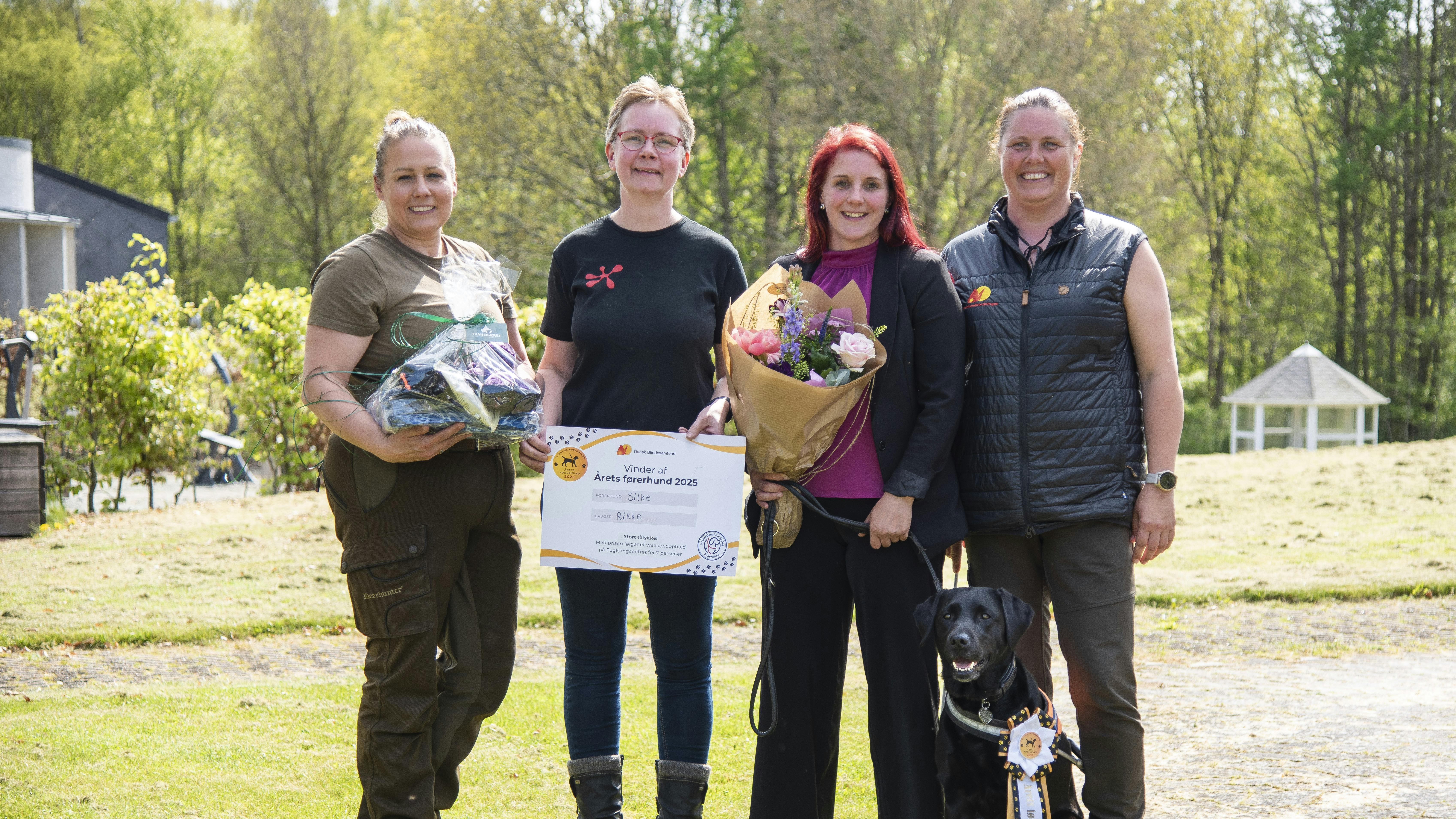 Rikke Hjortnæs med sin førerhund Silke ved sidstnævntes kåring som Årets Førerhund omgivet af Silkes fodervært, opdrætter og førerhundeinstruktør.