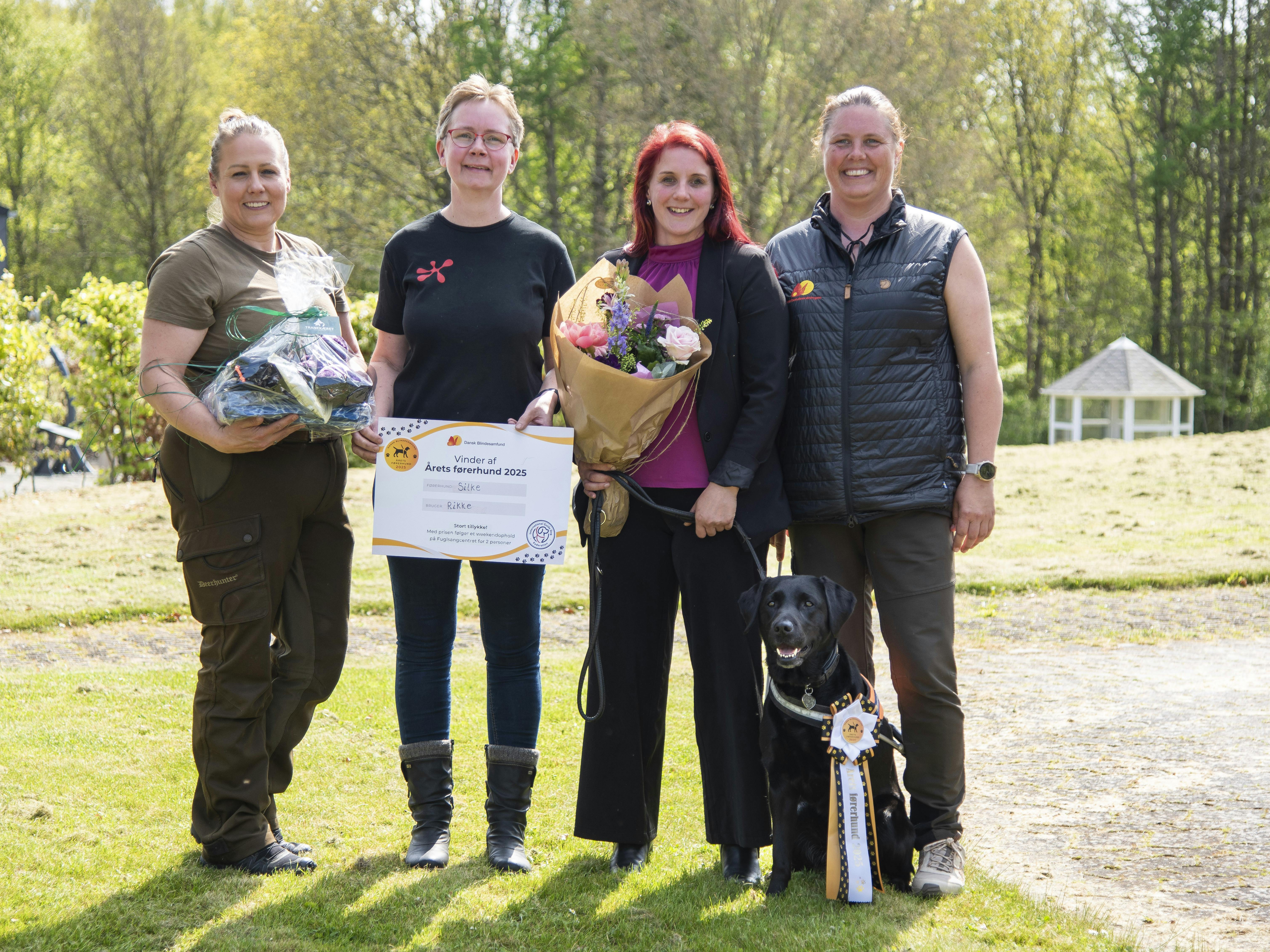 Rikke Hjortnæs med sin førerhund Silke ved sidstnævntes kåring som Årets Førerhund omgivet af Silkes fodervært, opdrætter og førerhundeinstruktør.