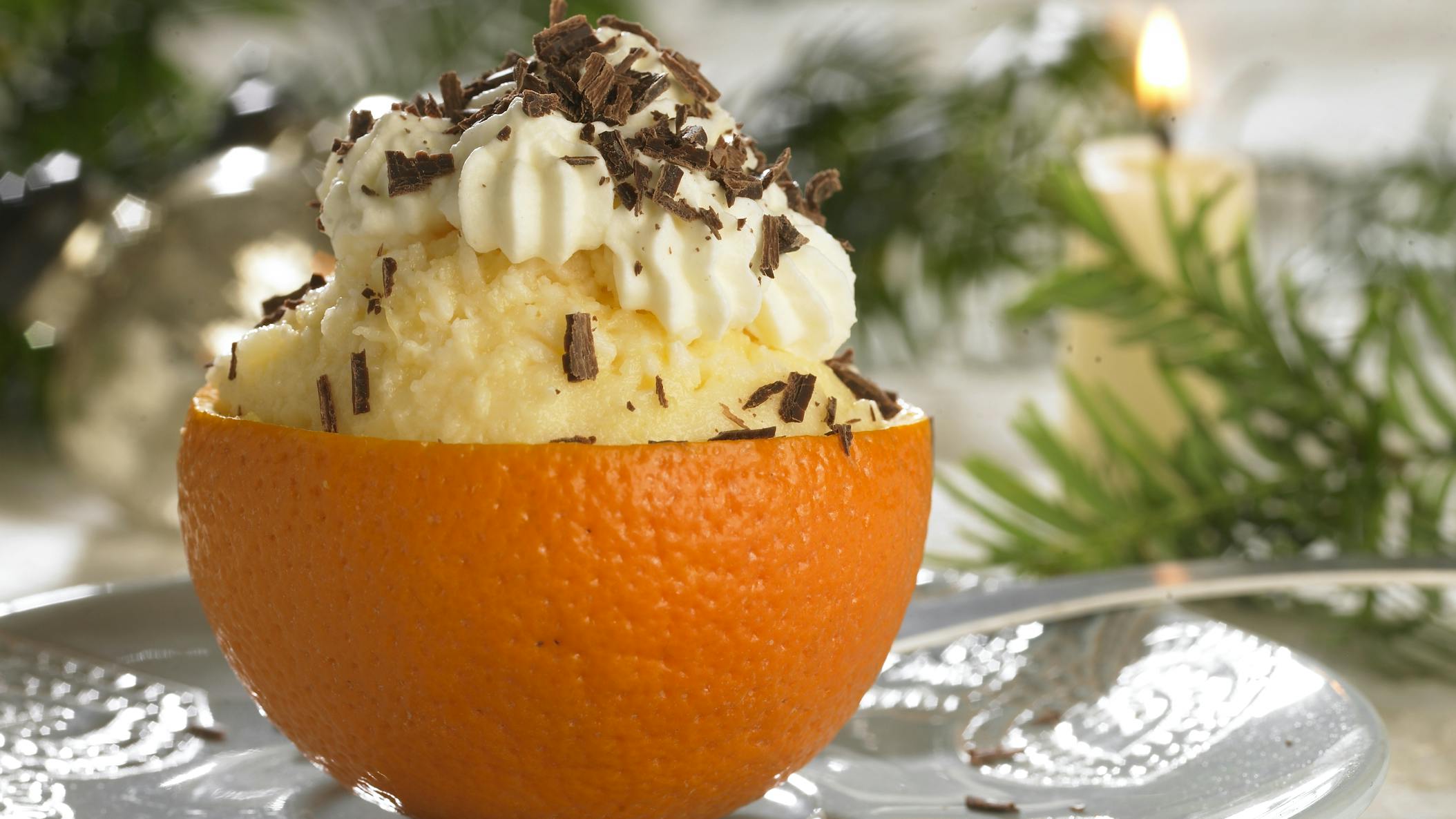 Lækker appelsinfromage med kokos serveret i appelsinskal