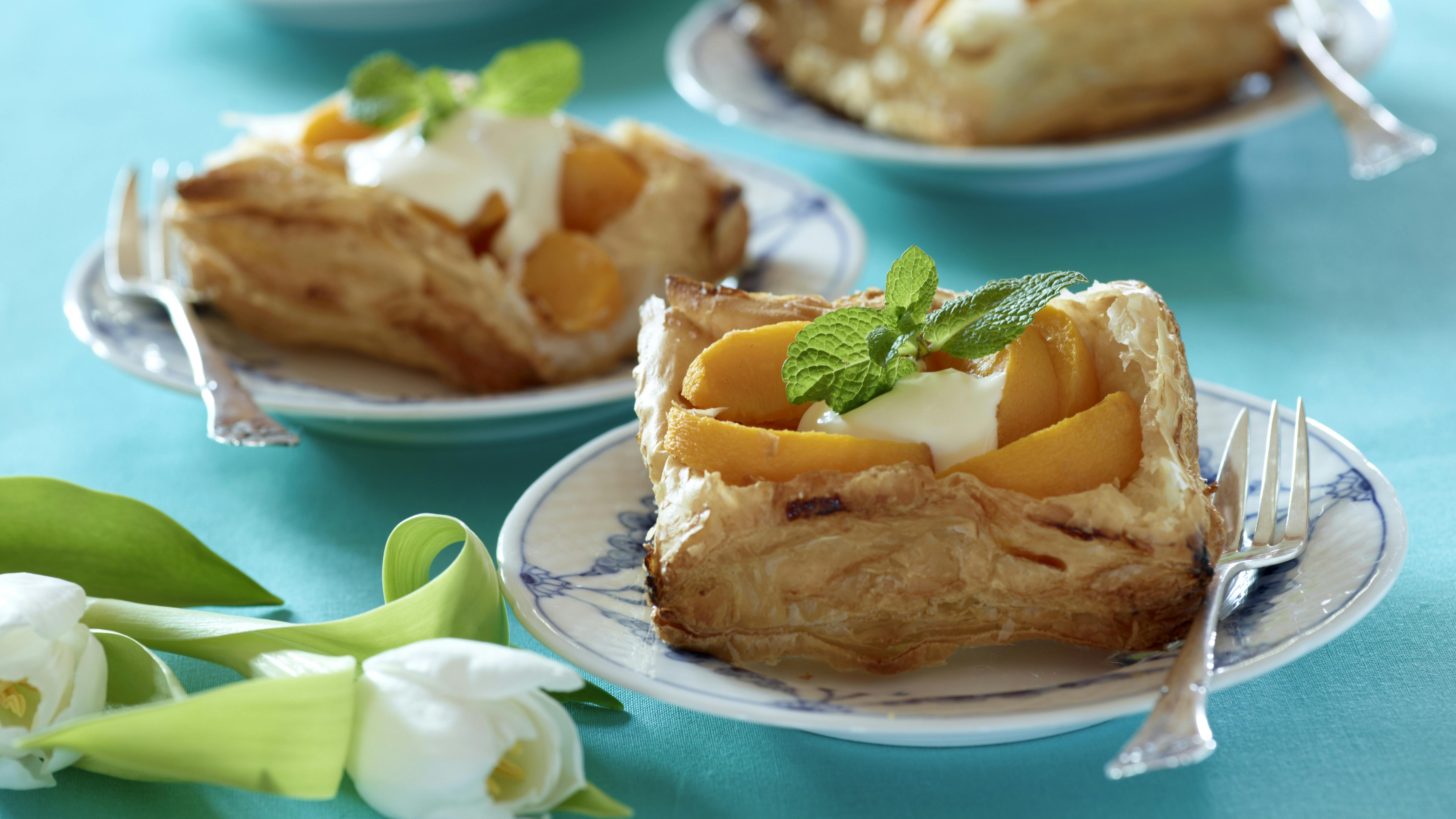 Fersken-puffere lavet på butterdej serveret med creme fraiche