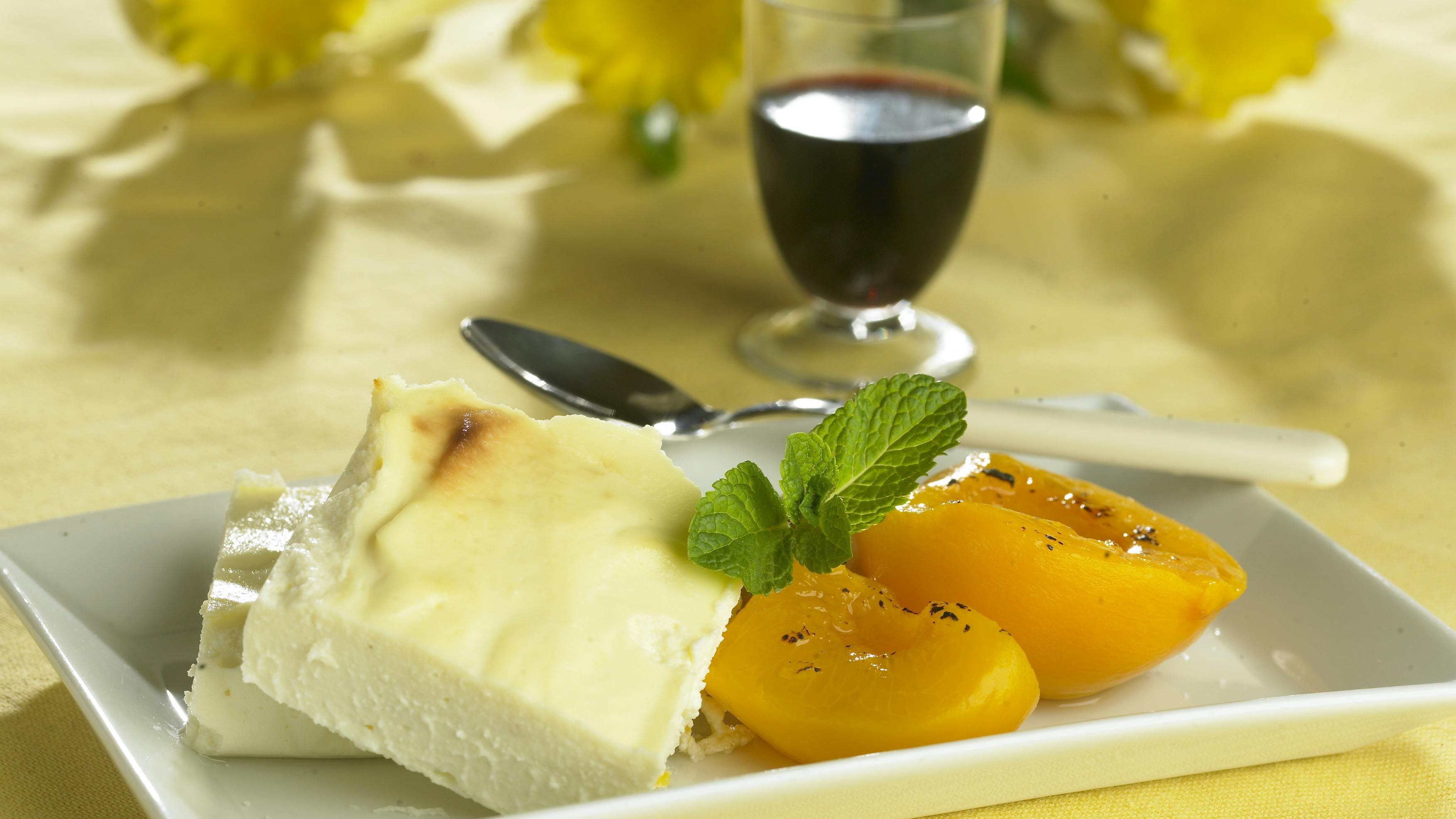 Pocherede ferskner i vanilje med bagt budding