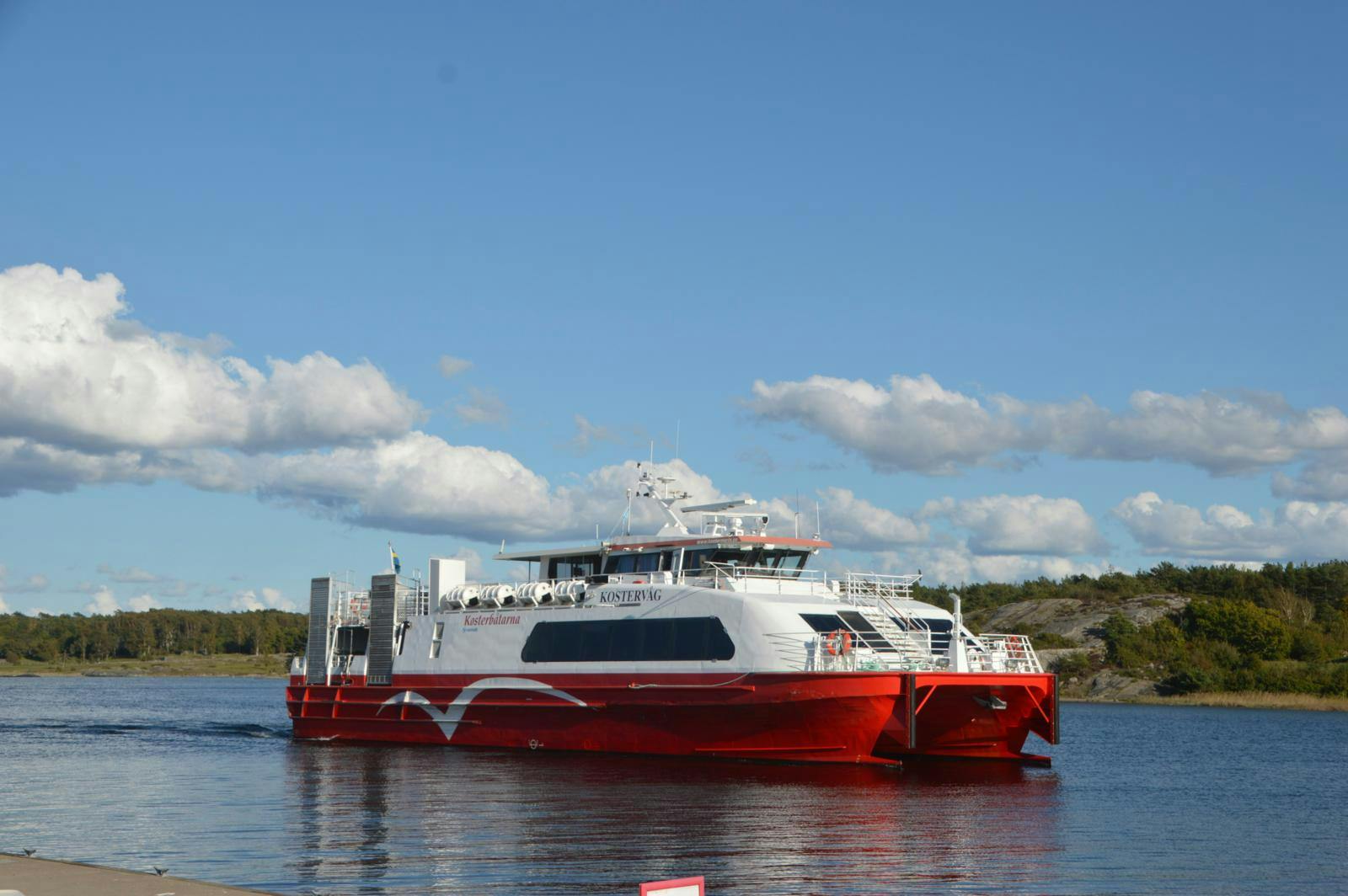 En rød og hvid færge sejler på havet.