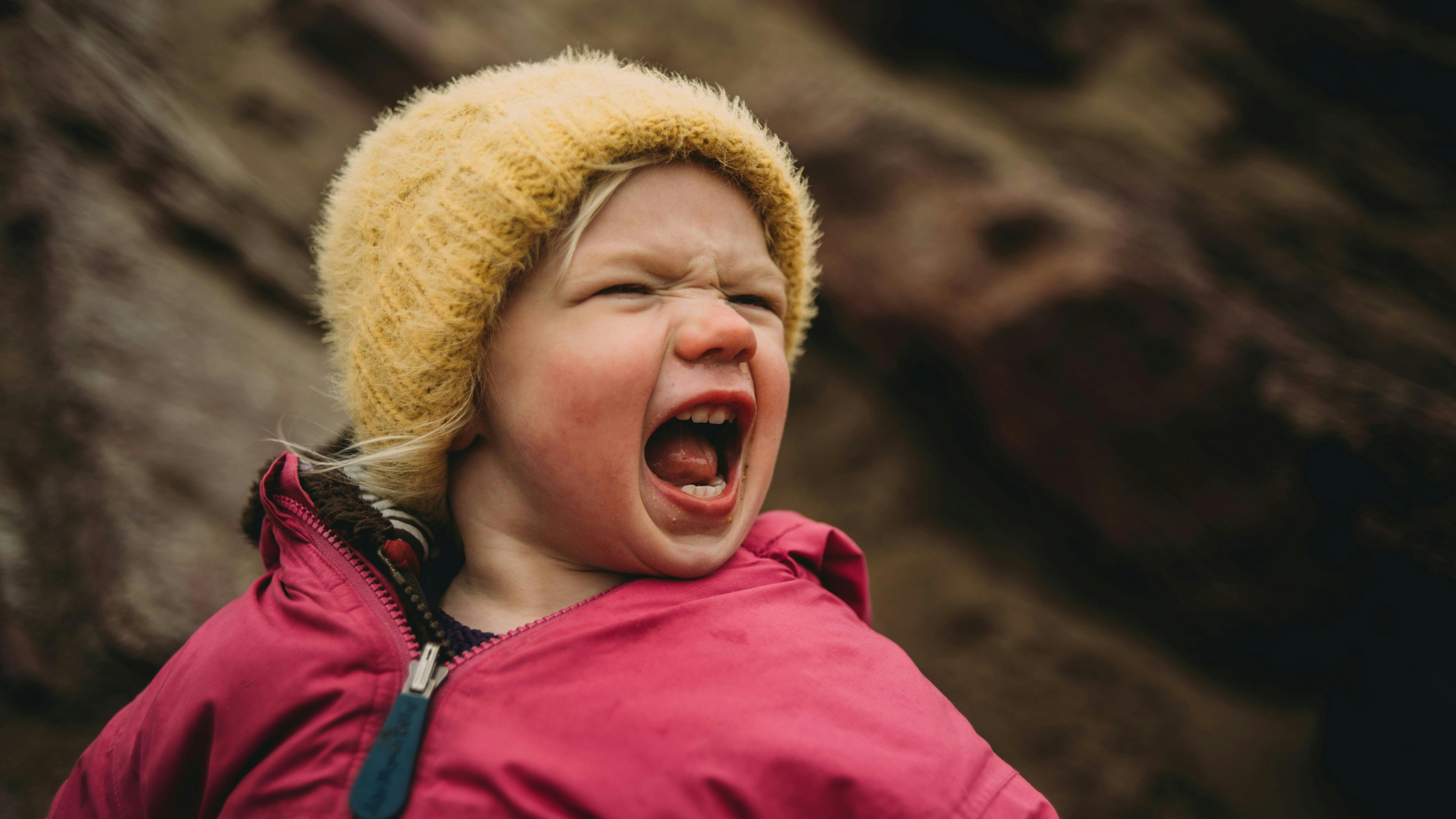 Et barn, der råber og ser lidt fræk ud.