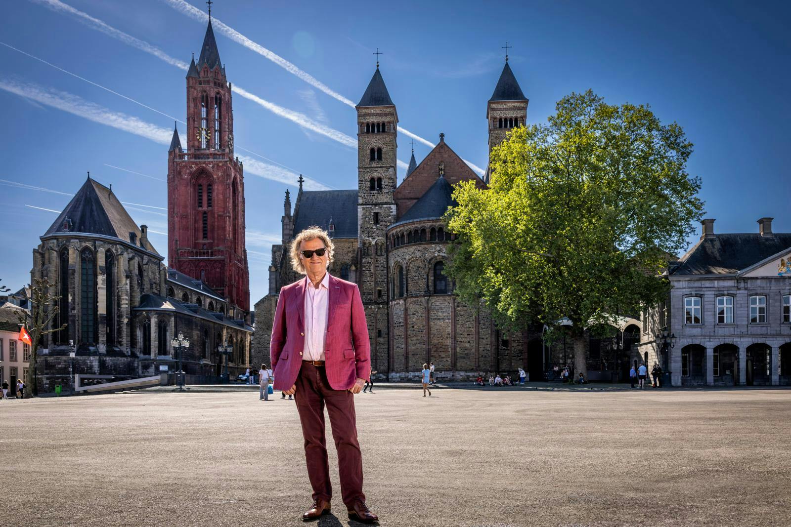 André Rieu står midt på Vrijthof-torvet foran to kirker i Maastricht.