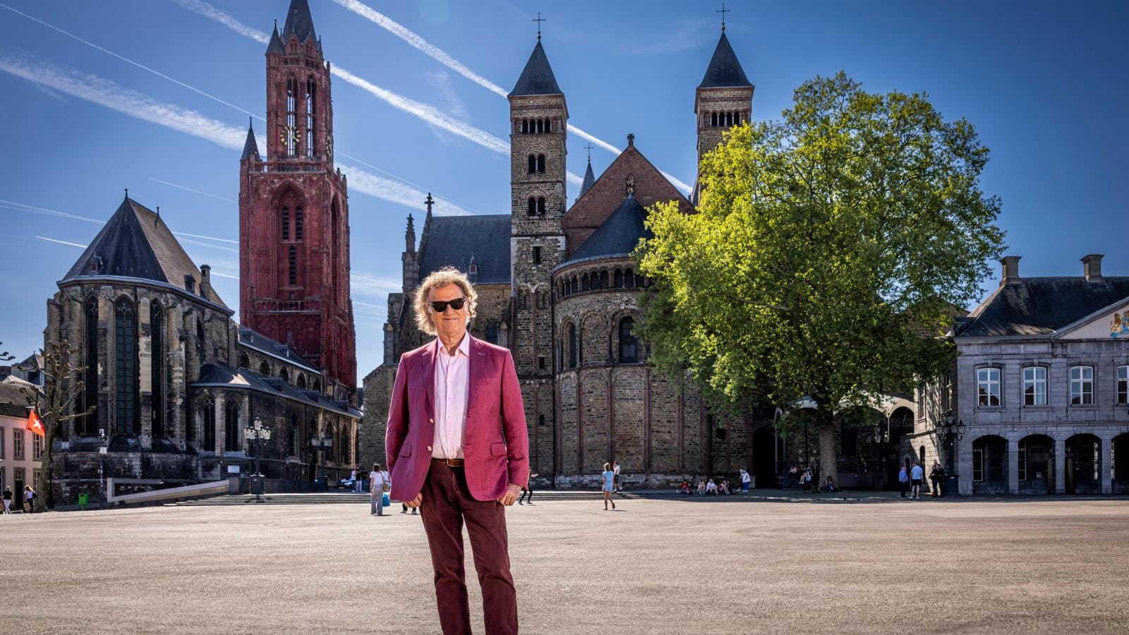 André Rieu står midt på Vrijthof-torvet foran to kirker i Maastricht.