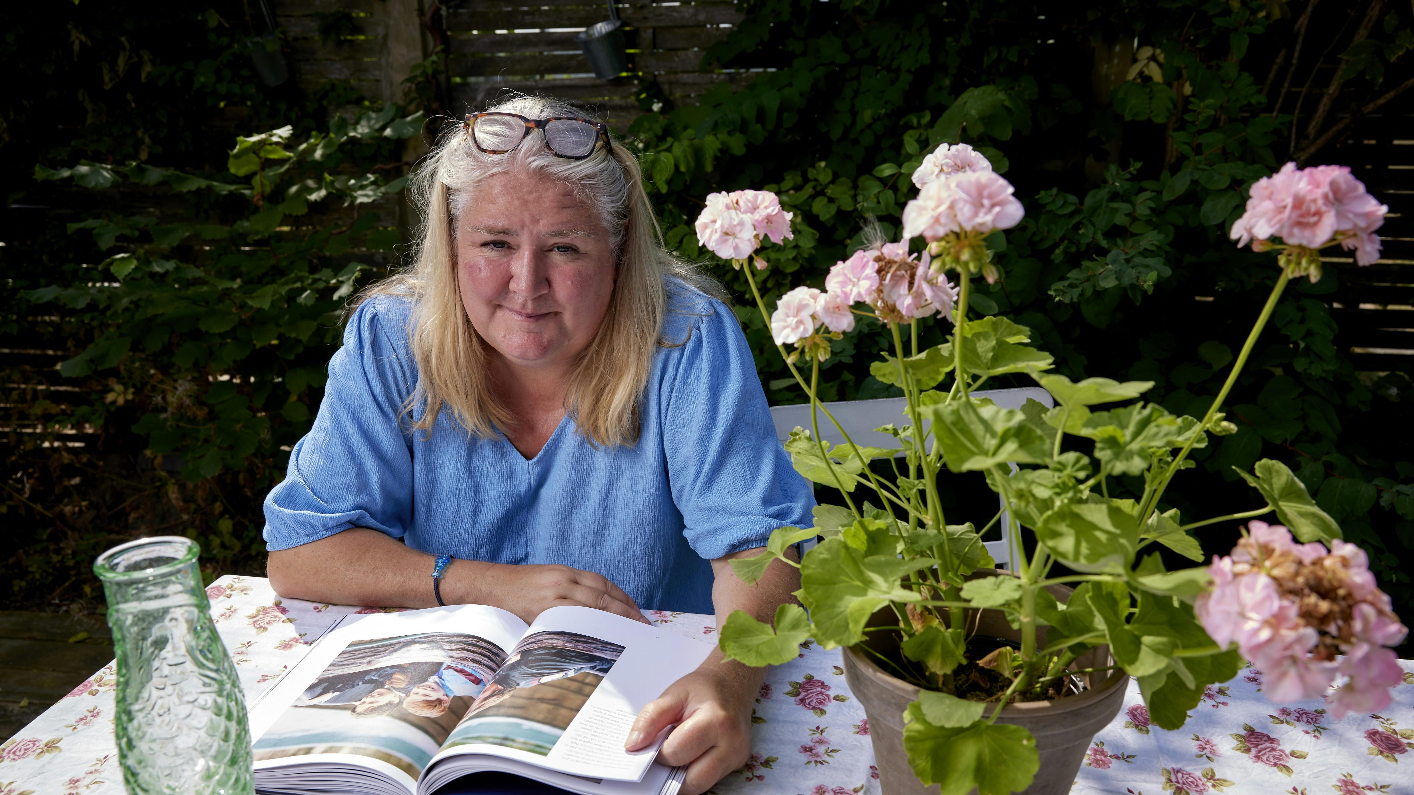 Lone Theils sidder ved bord i have