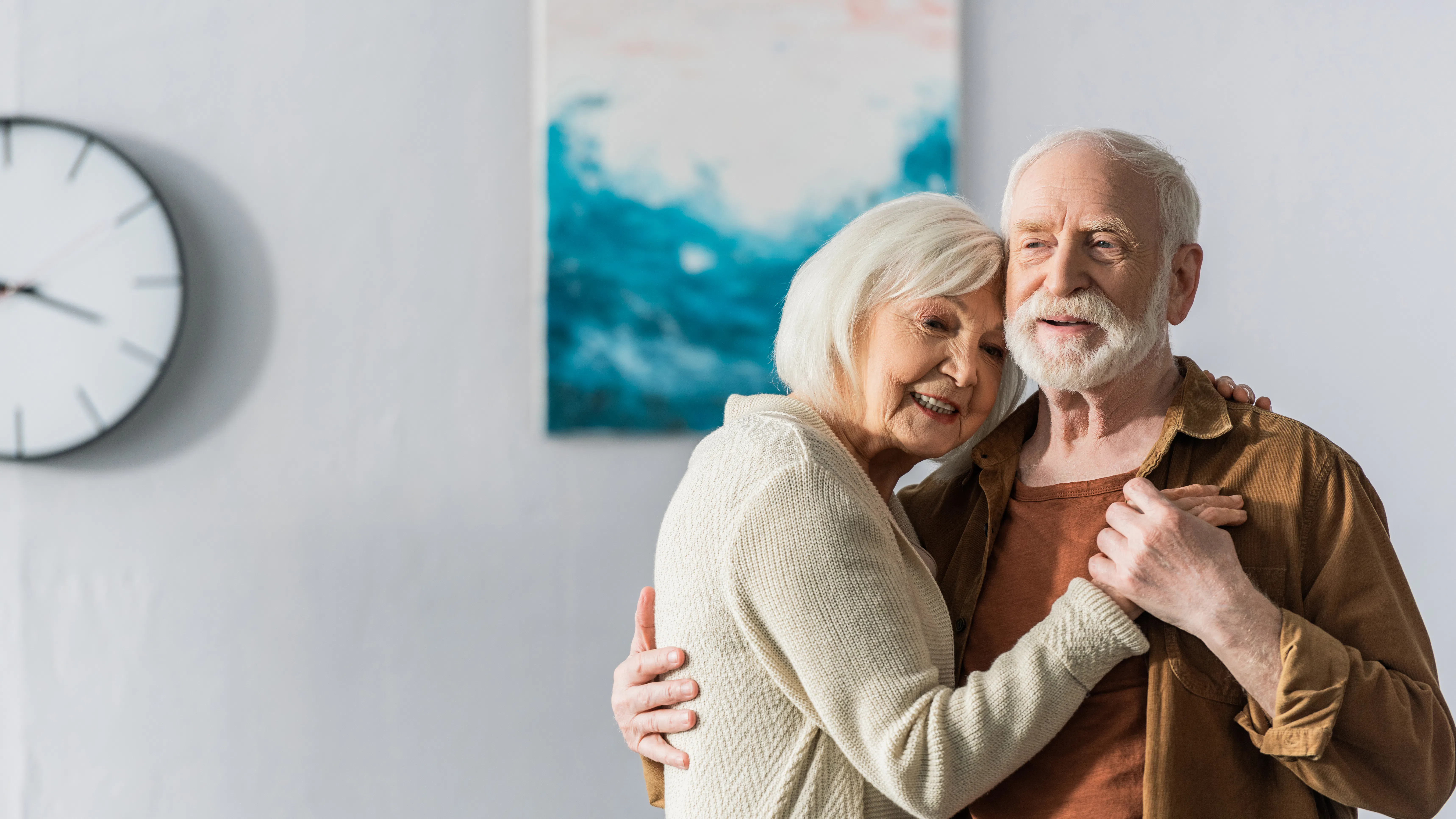 Ældre ægtepar smiler og holder om hinanden