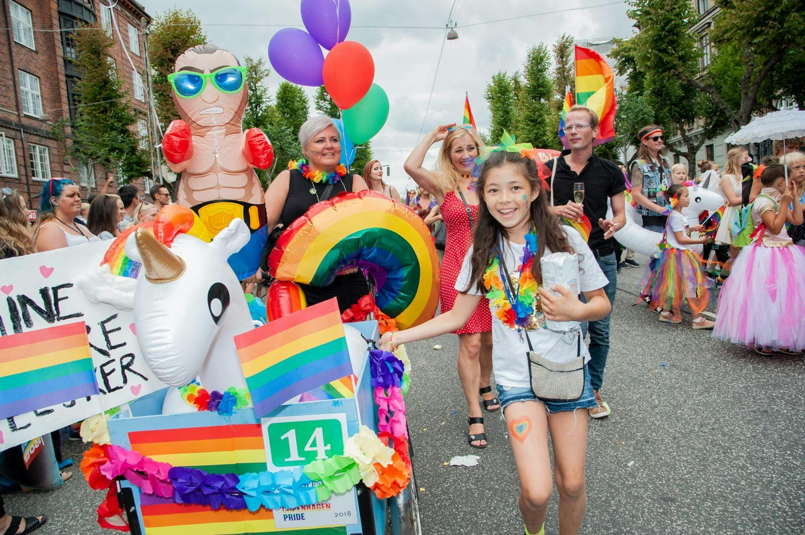 Pride parade optog med børn og voksne og regnbueflag