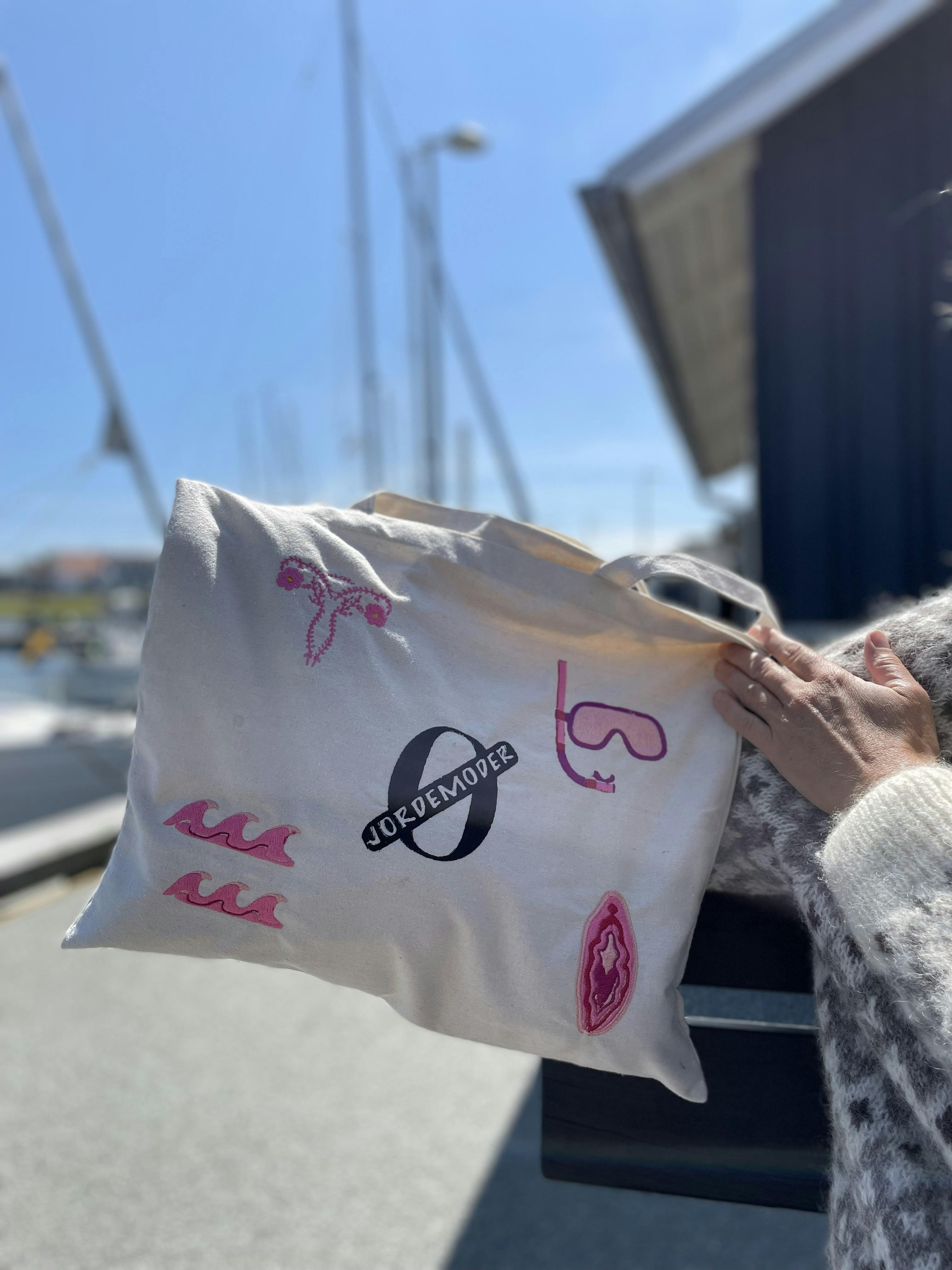 Mulepose med motiver, der handler om fødsel og graviditet