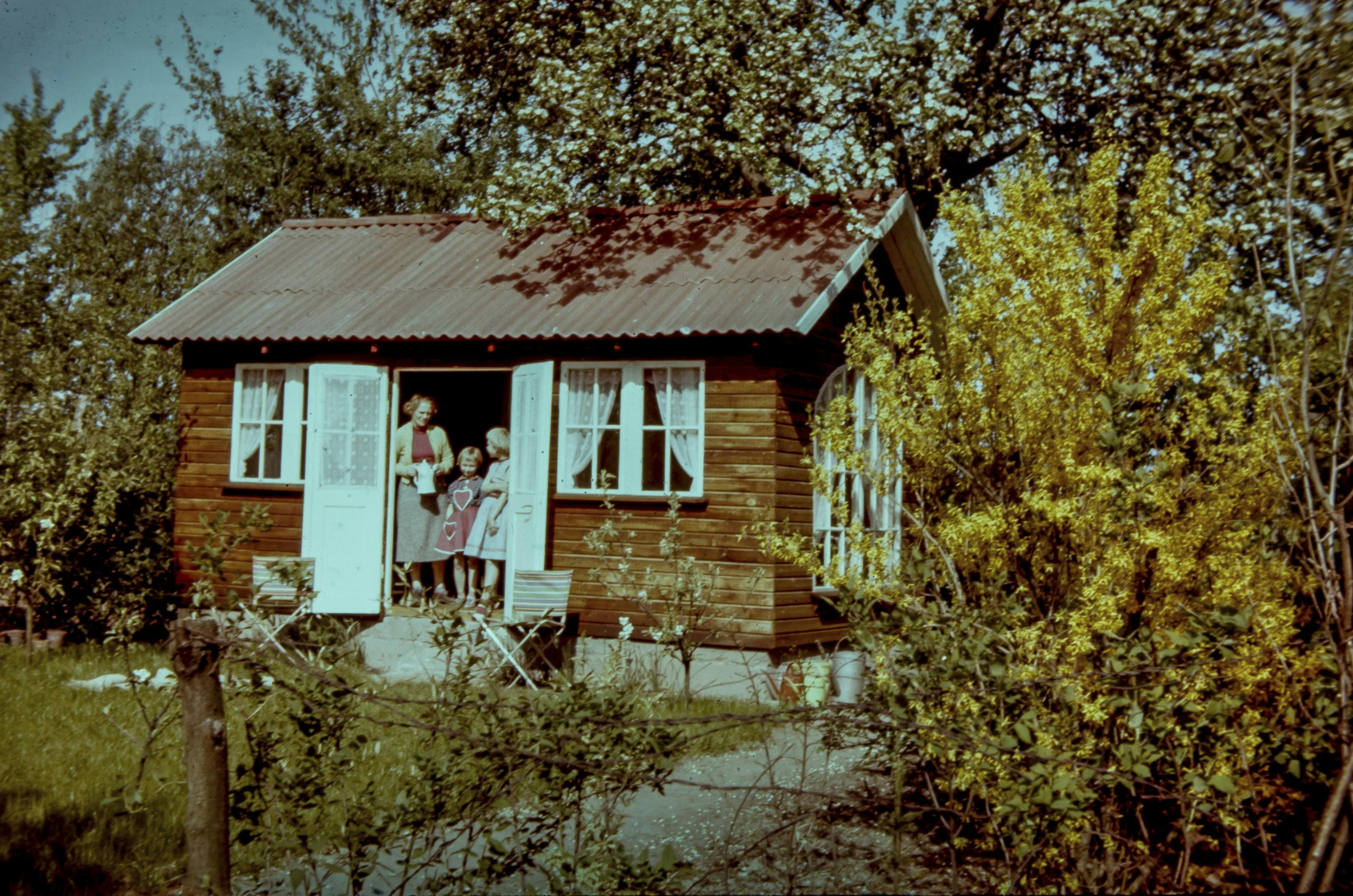 Søstrene Birgit Støchkel og Karen Margrethe Lauridsen som børn med deres mor i familiens kolonihavehus i Hjelmhaverne.