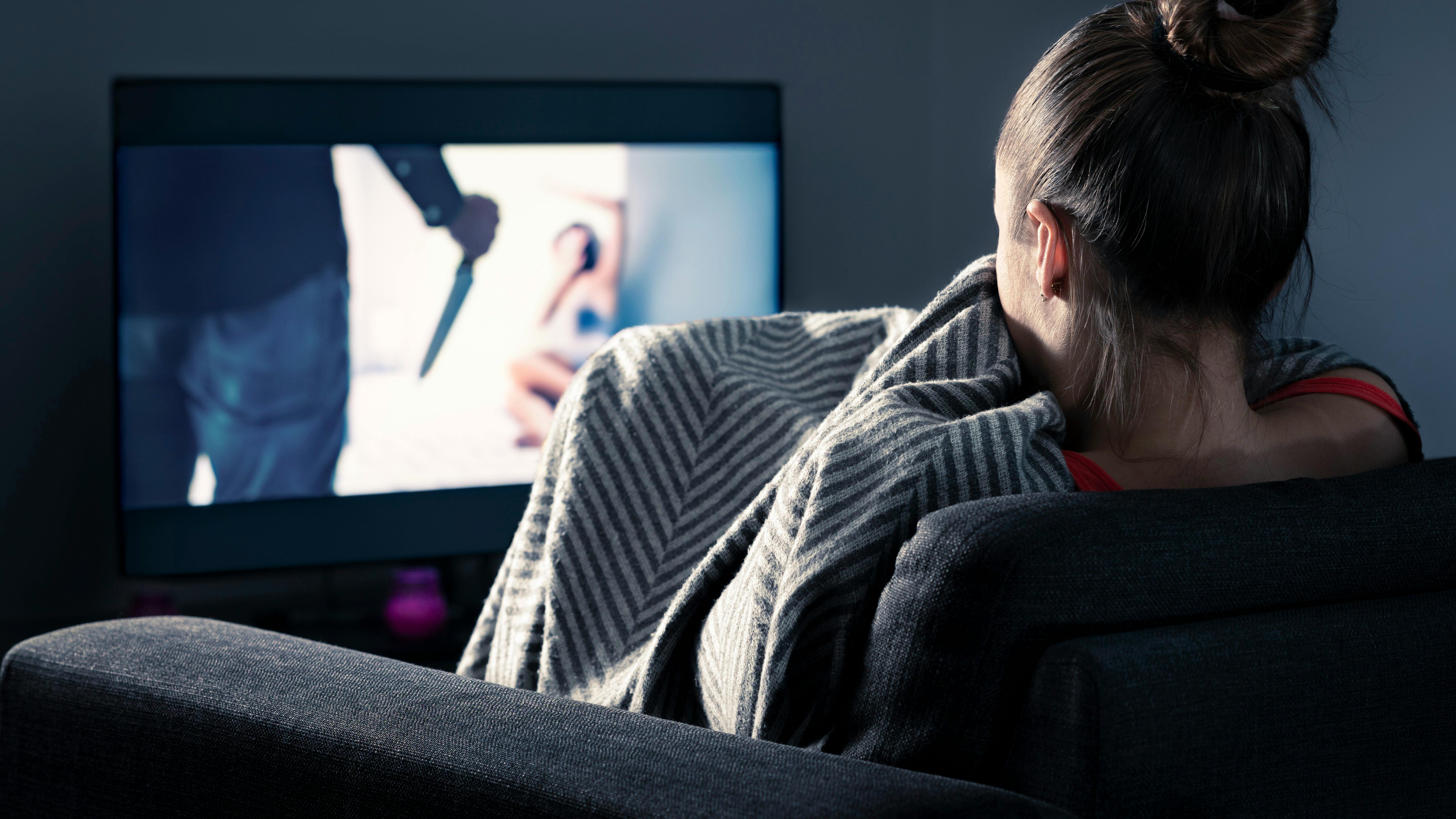 Kvinde der ser en uhyggelig film.