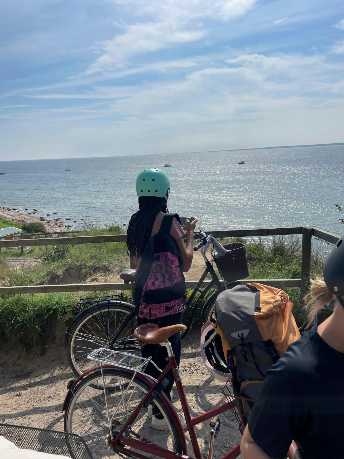 Et barn med en cykel kigger ud over havet.