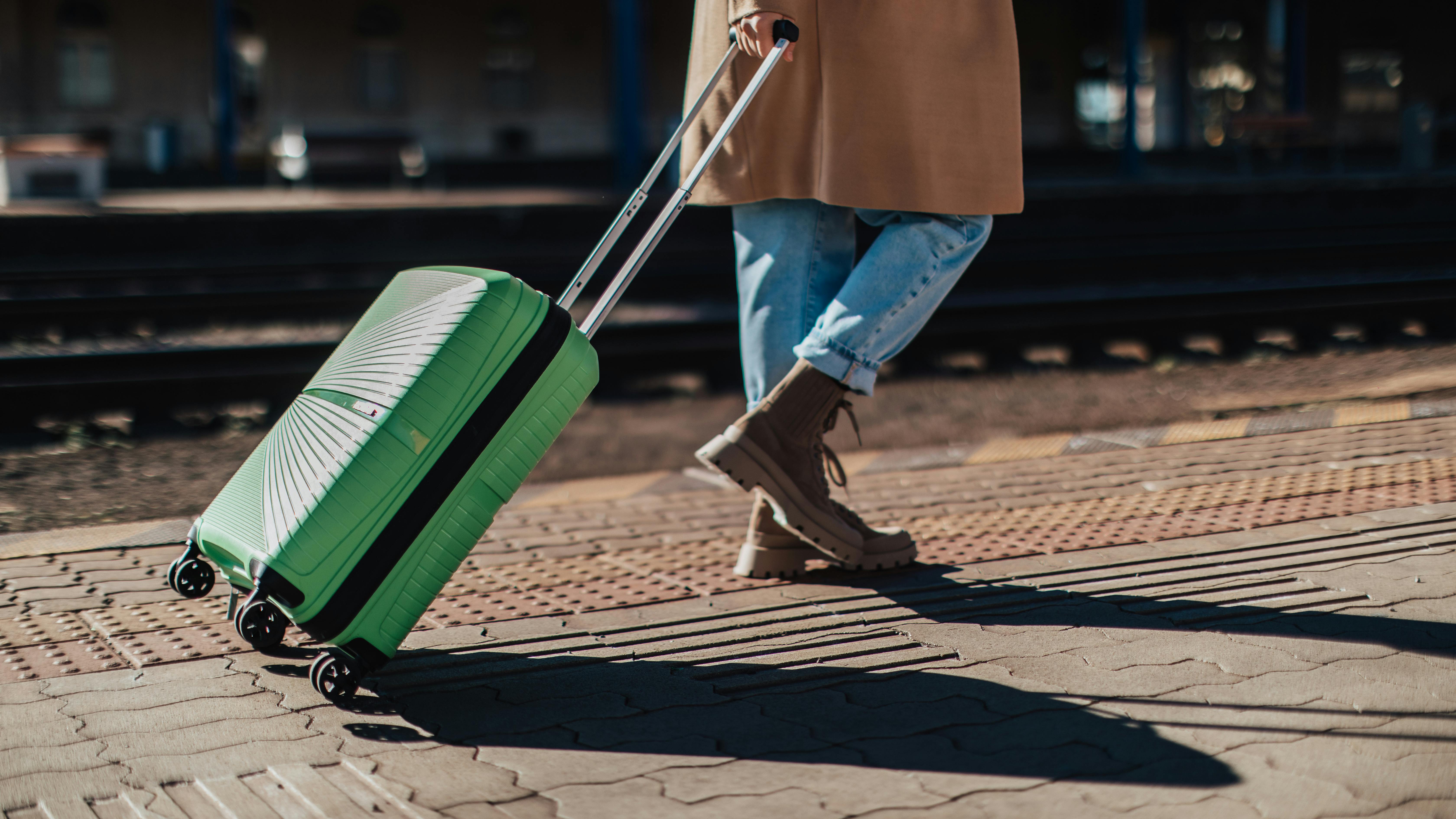 Kvinde med kuffert på station