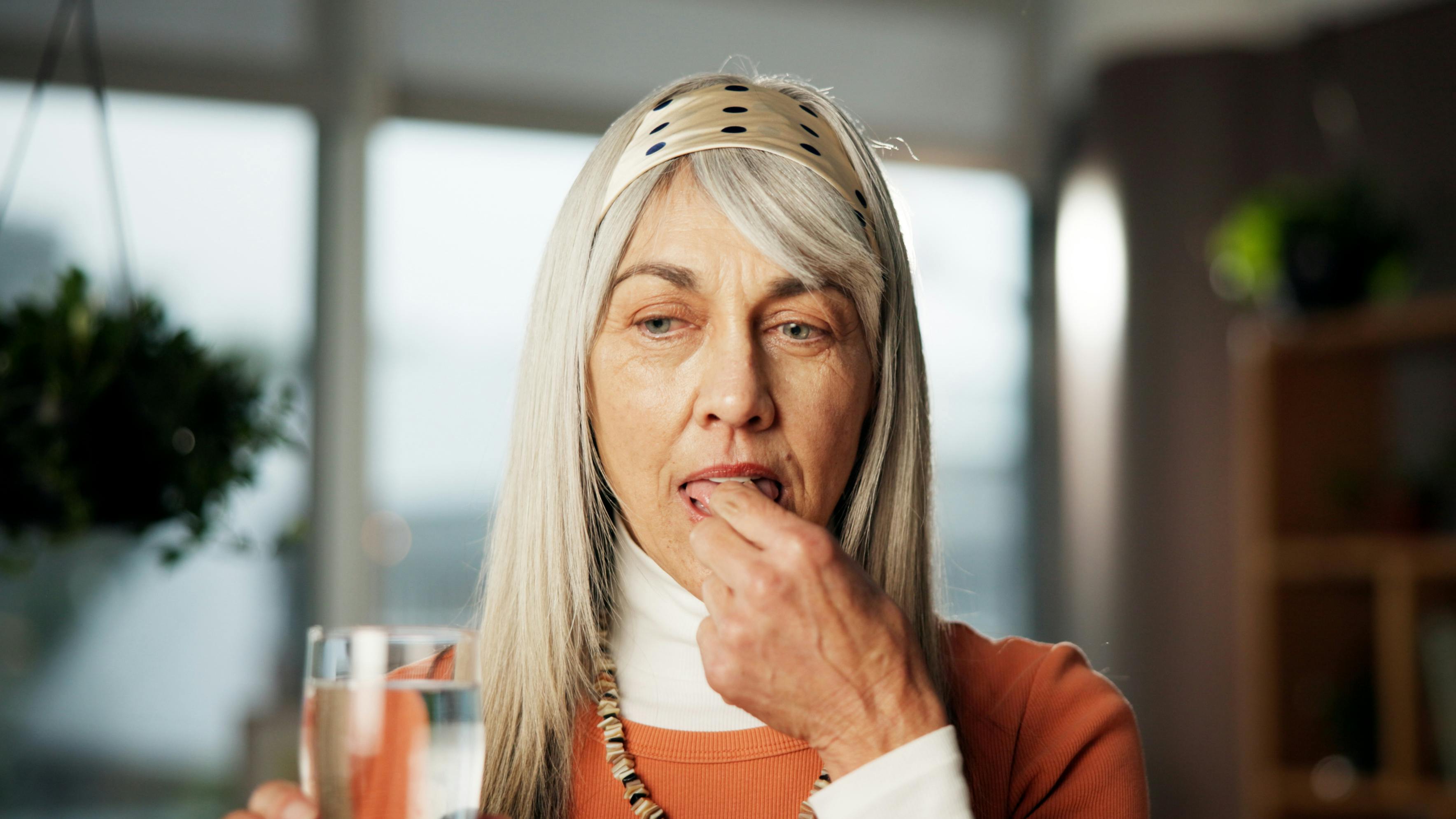 Ældre kvinde tager en pille