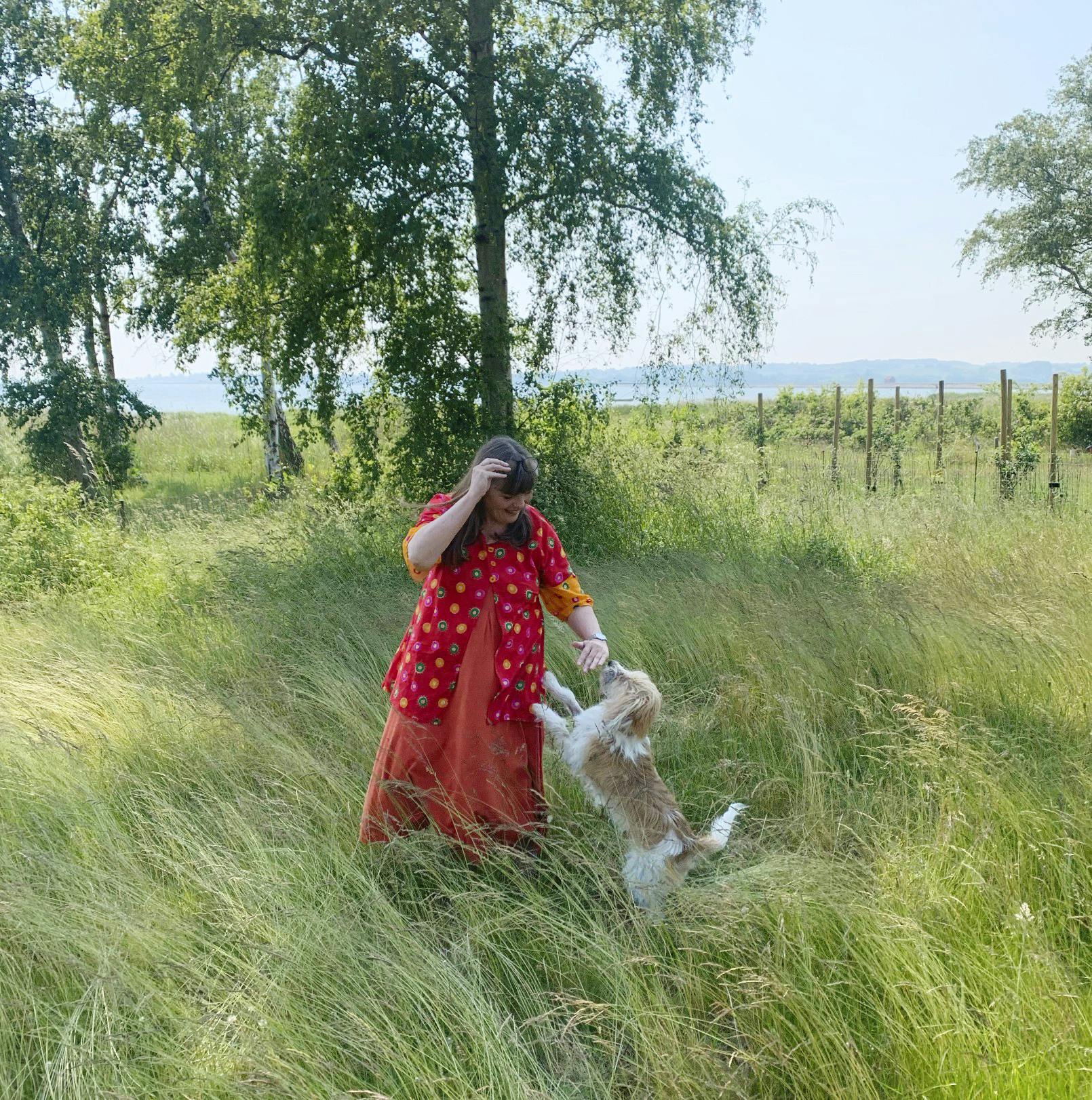 Anna Grue står med sin hund i haven