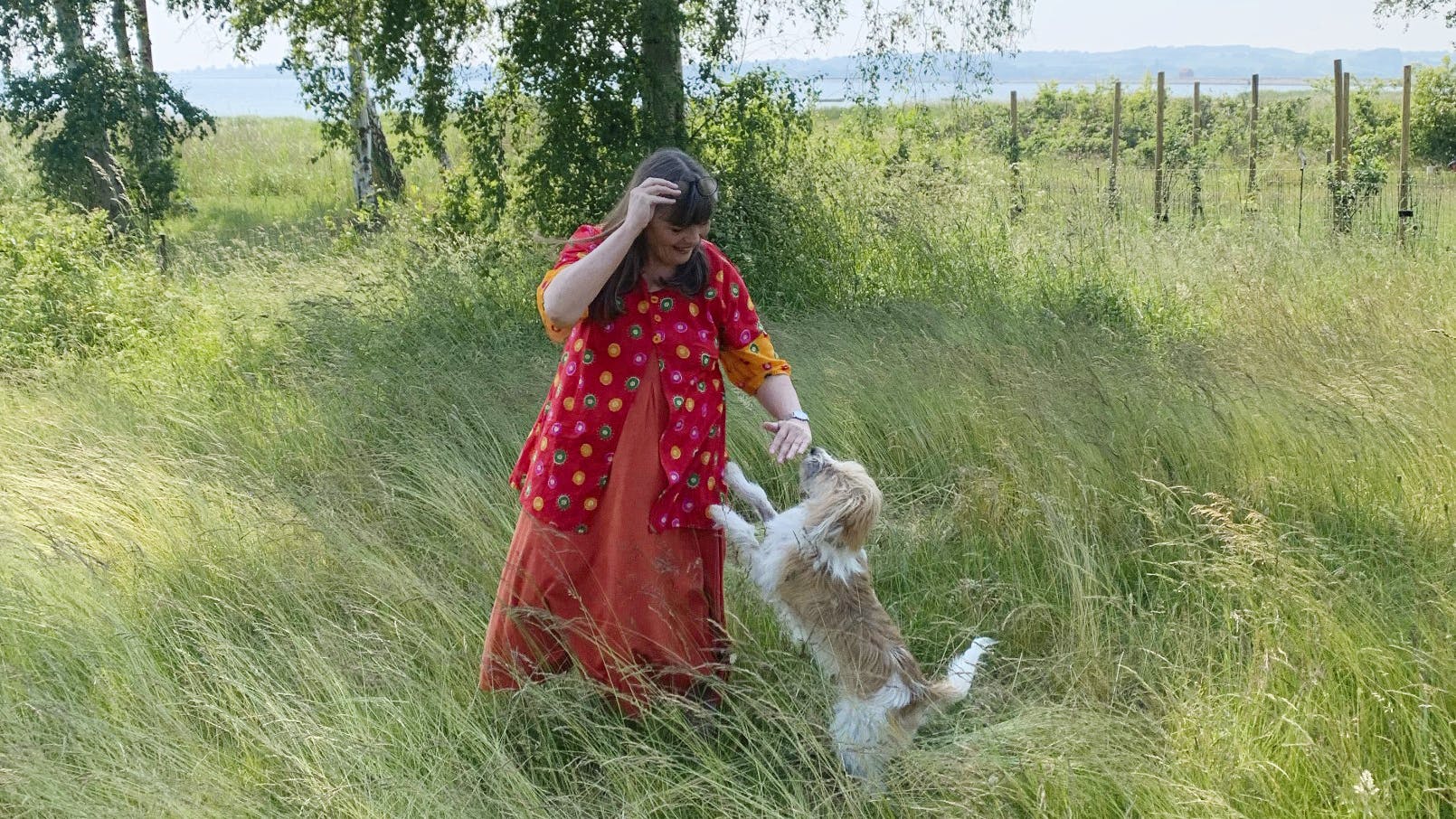 Anna Grue står med sin hund i haven
