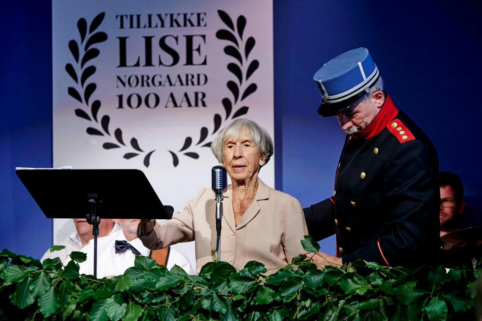 Lise Nørgaard der står på et podie og holder tale.