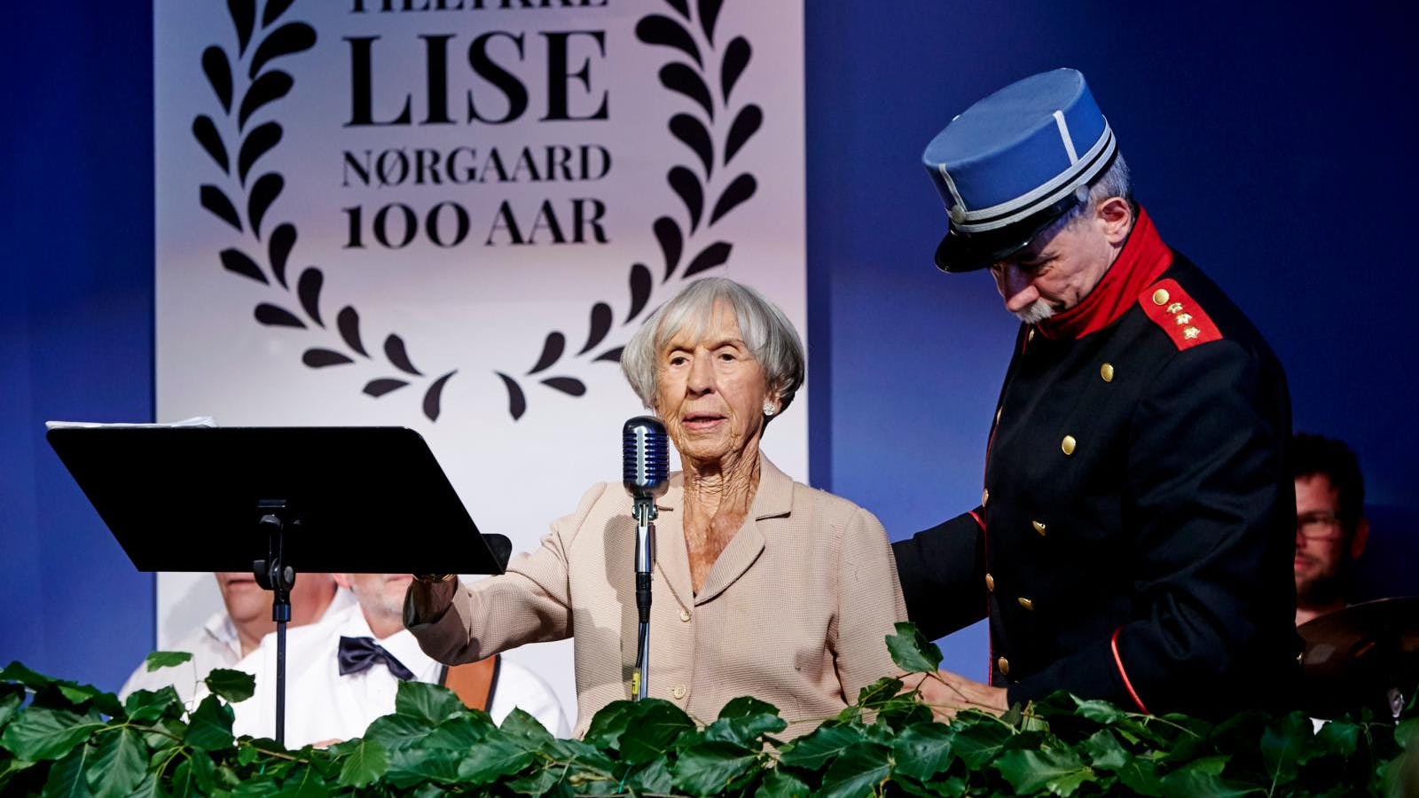 Lise Nørgaard der står på et podie og holder tale.