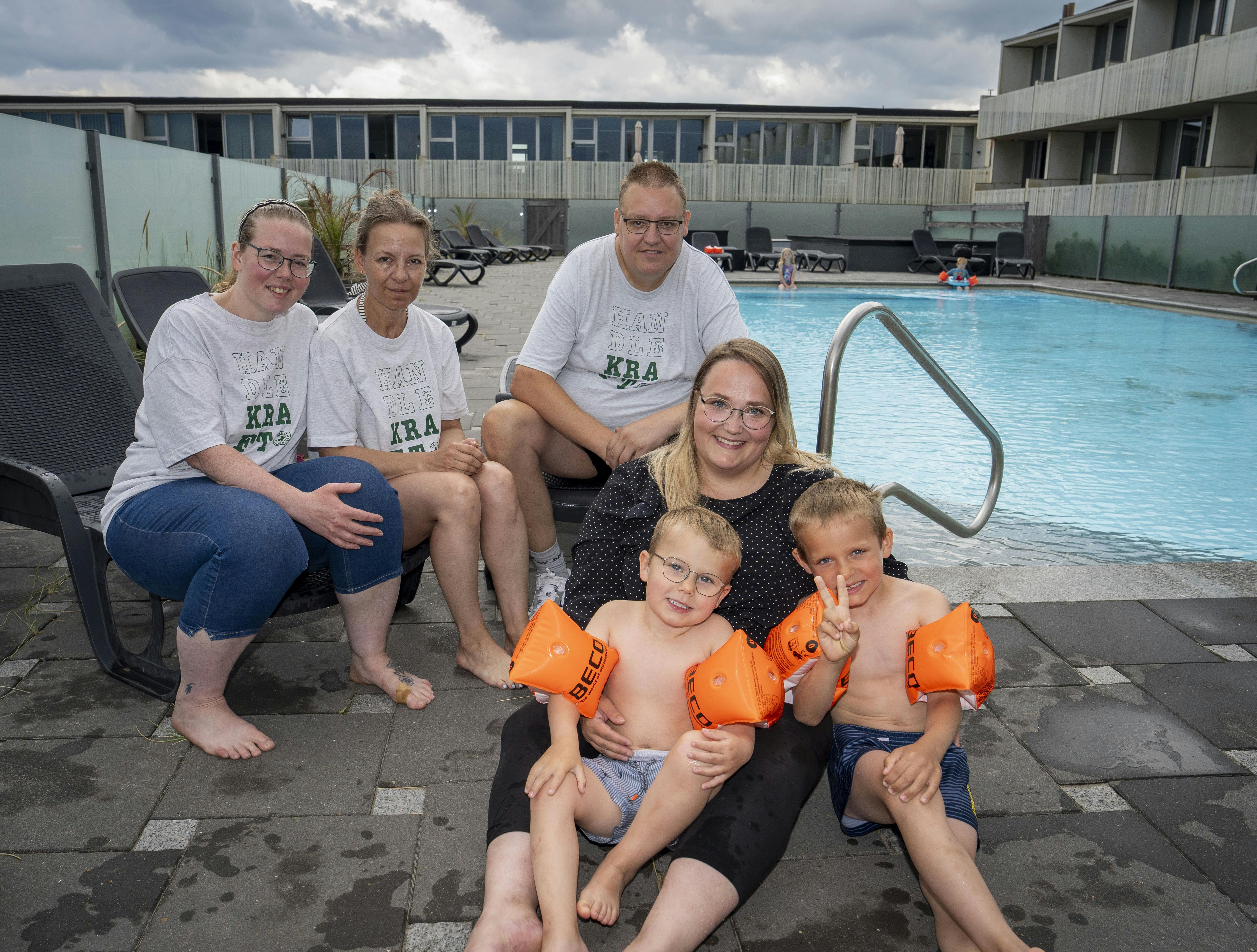 Brian Nielsen sidder ved poolen i Blokhus med sine to hjælpere Anja og Jane i selskab med feriegæsten Katrine Moshave med sønnerne, Theo og Melvin