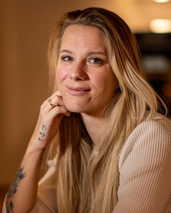 Anja sidder i stue med stearinlys i baggrund