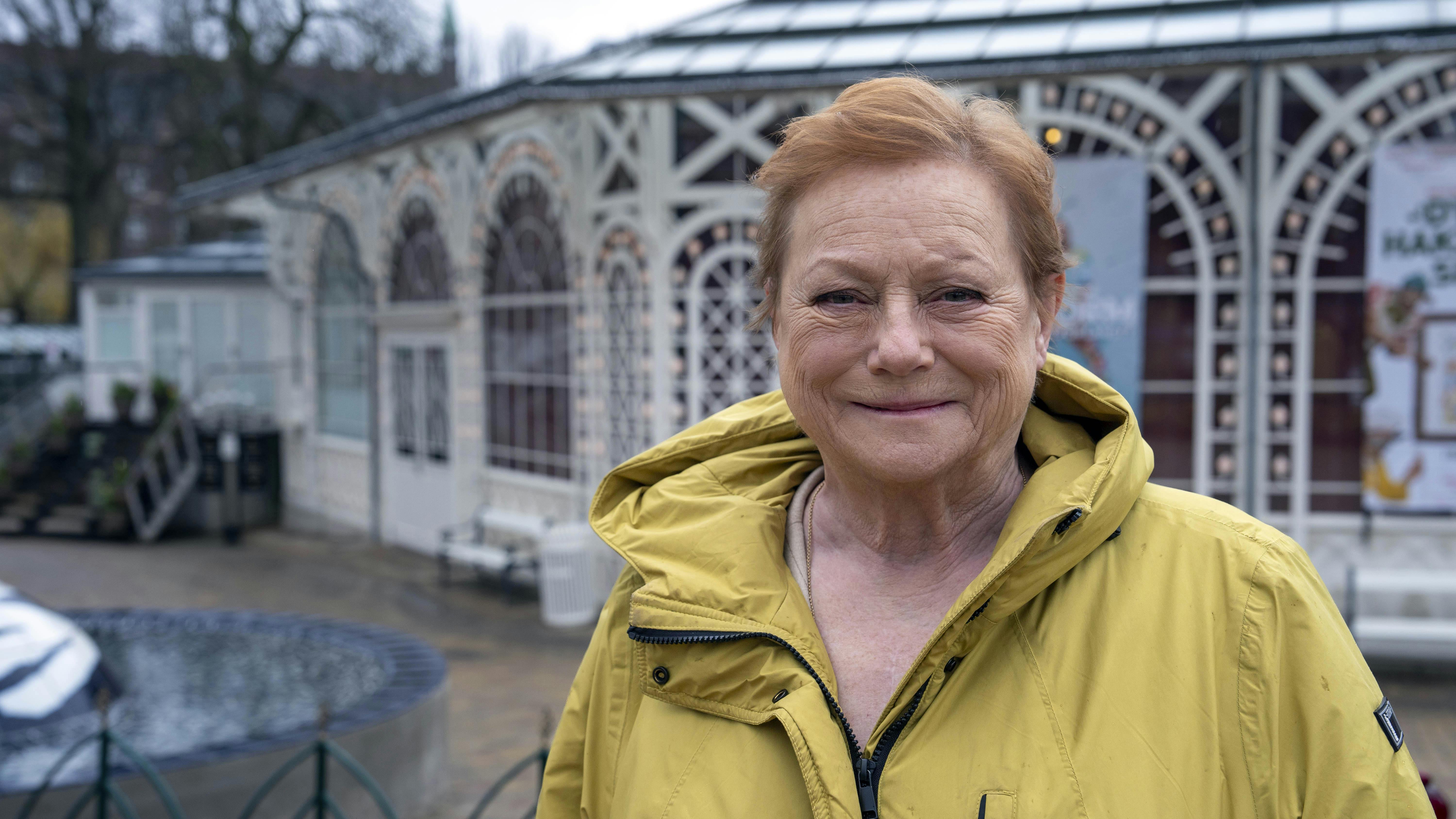 Lisbet Dahl står foran Glassalen i Tivoli iført en gul jakke
