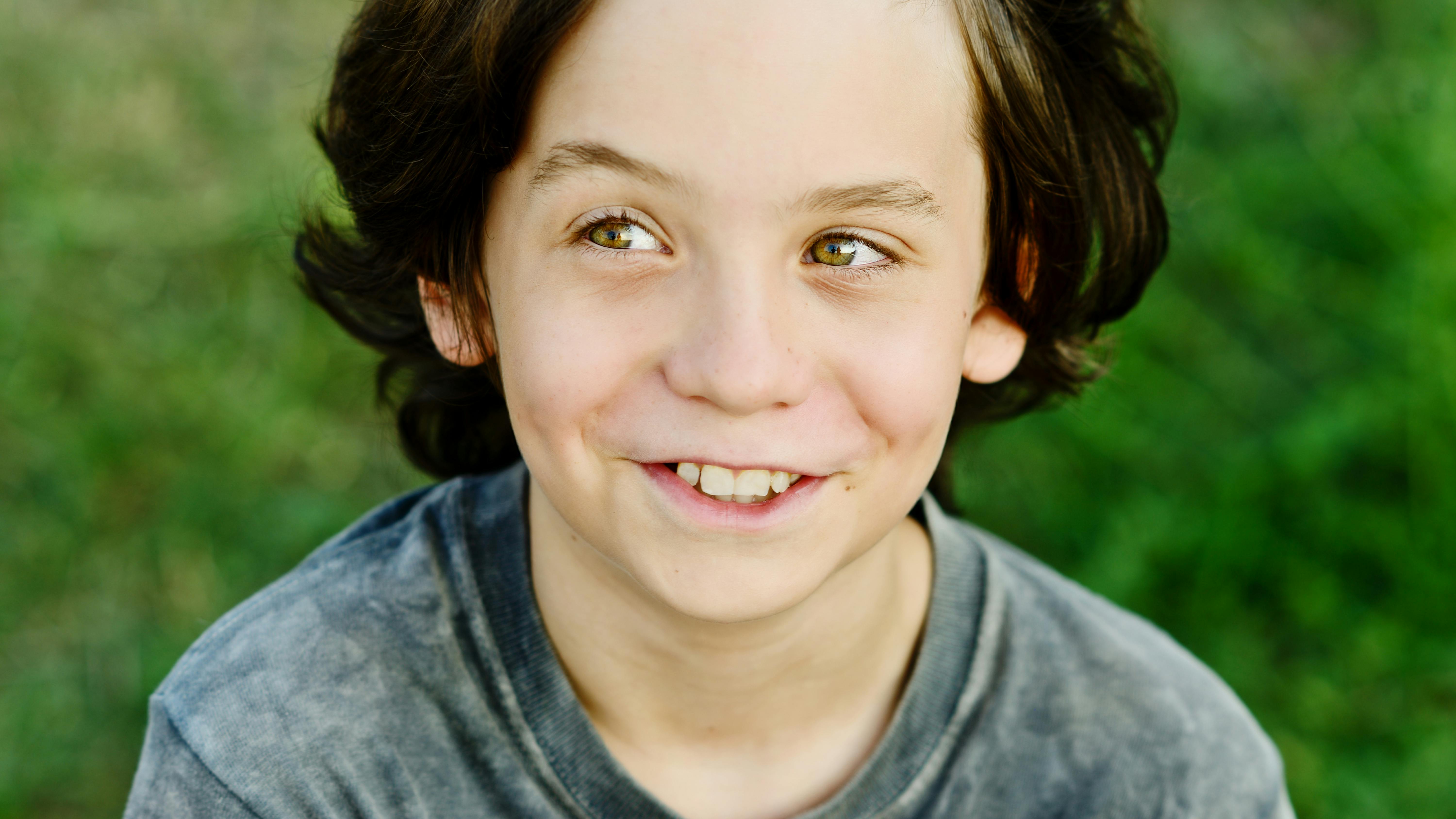 Dreng med langt hår, der smiler