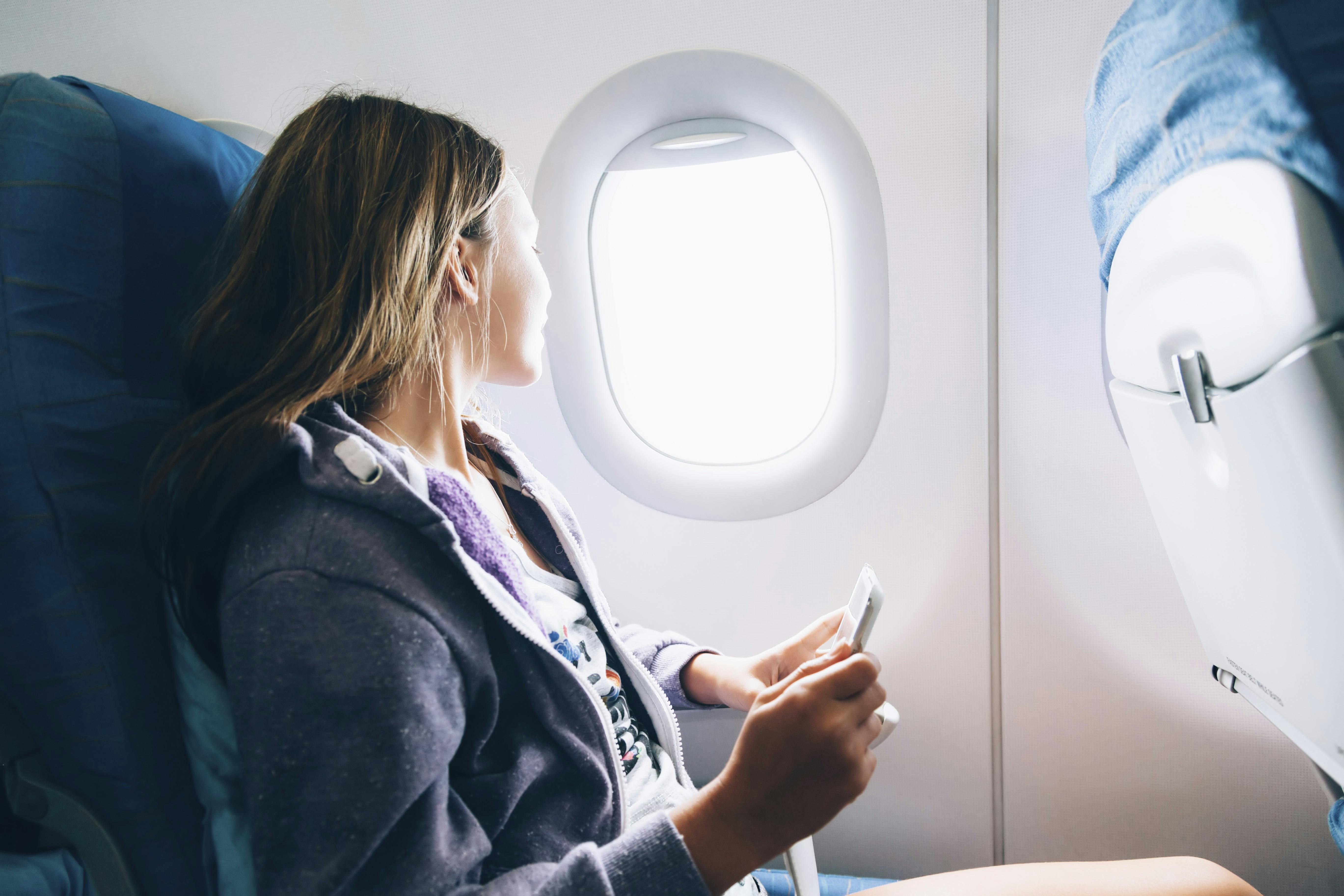 Kvinde sidder ved vindue i fly