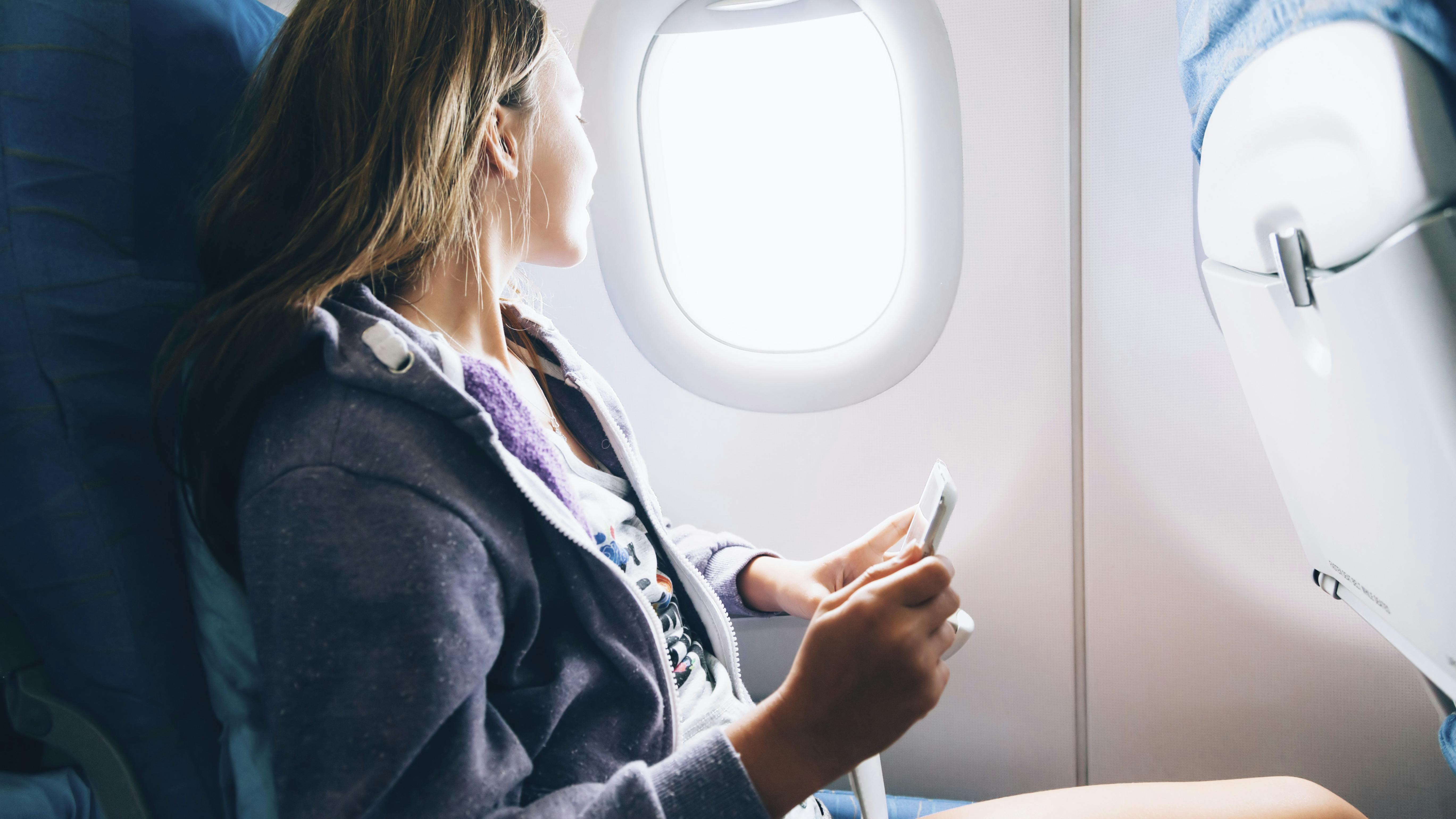 Kvinde sidder ved vindue i fly