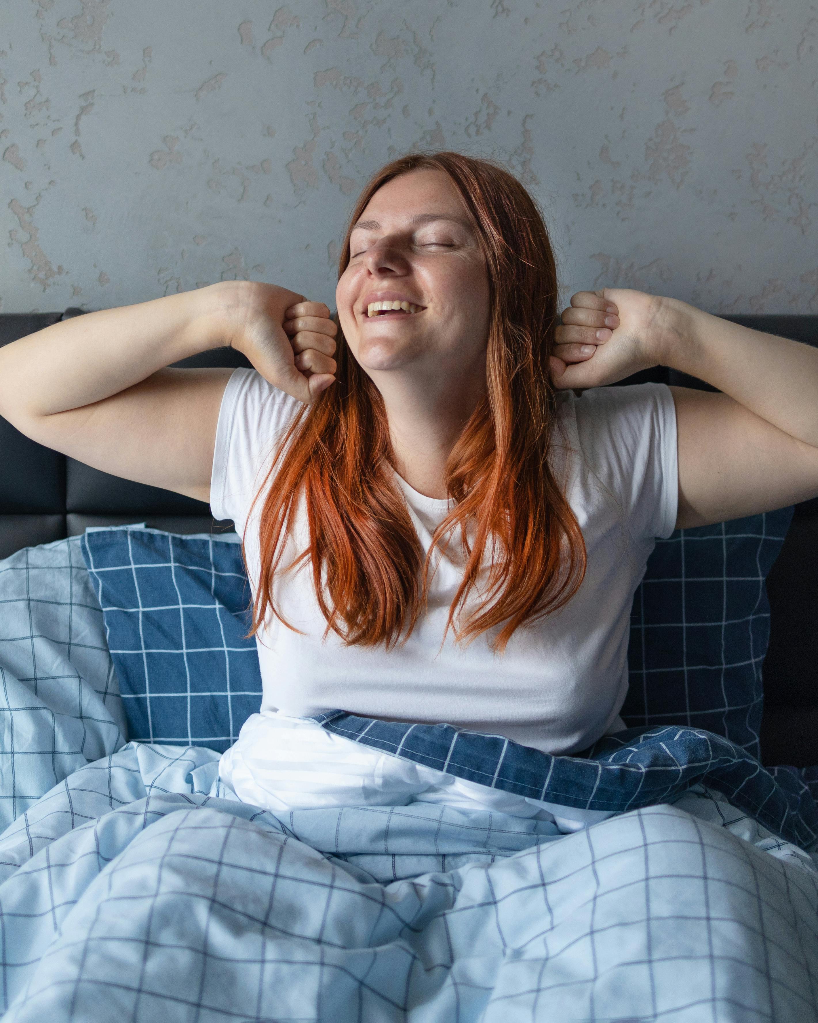 Kvinde strækker sig i sengen