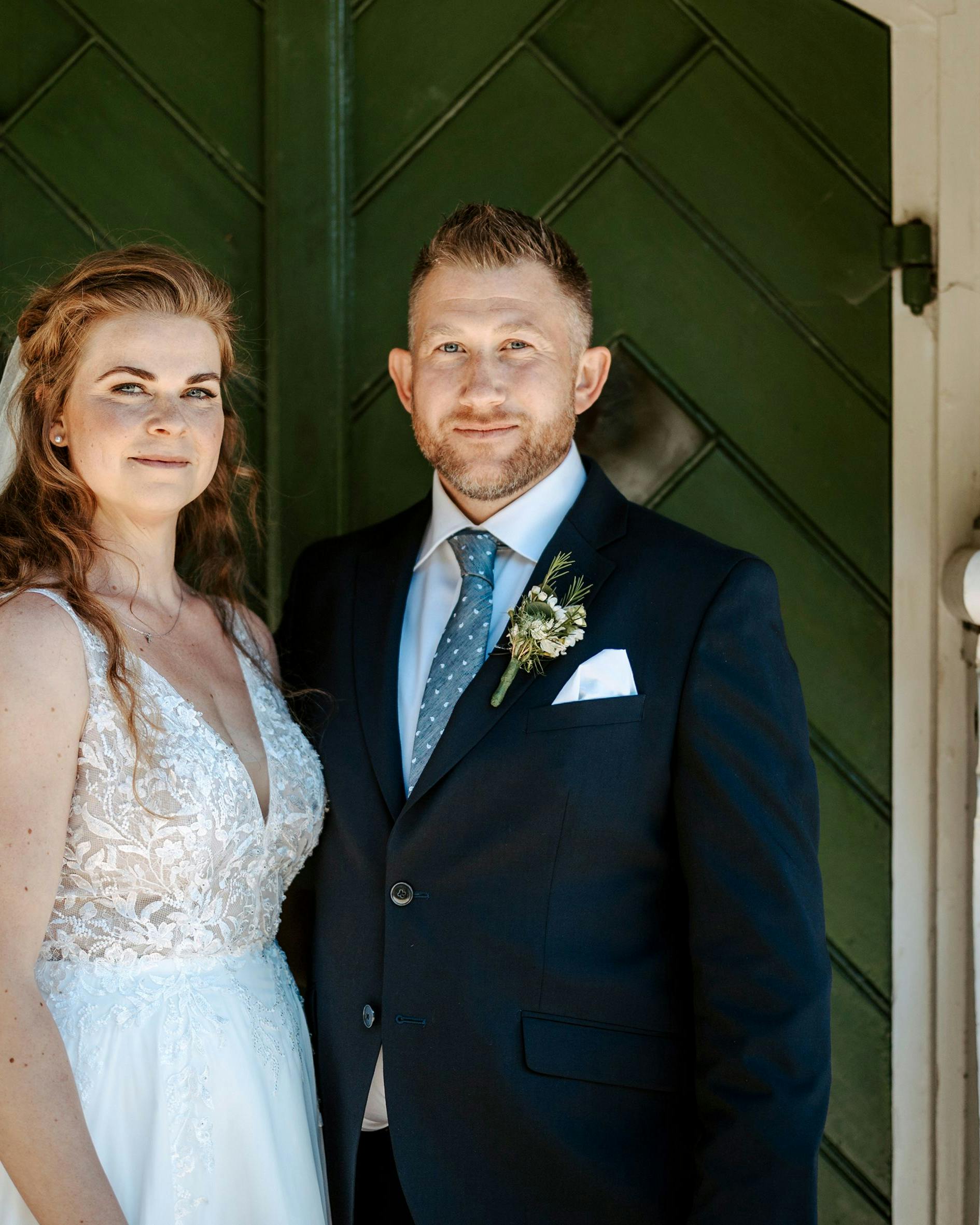 Et brudepar, der smiler forsigtigt.