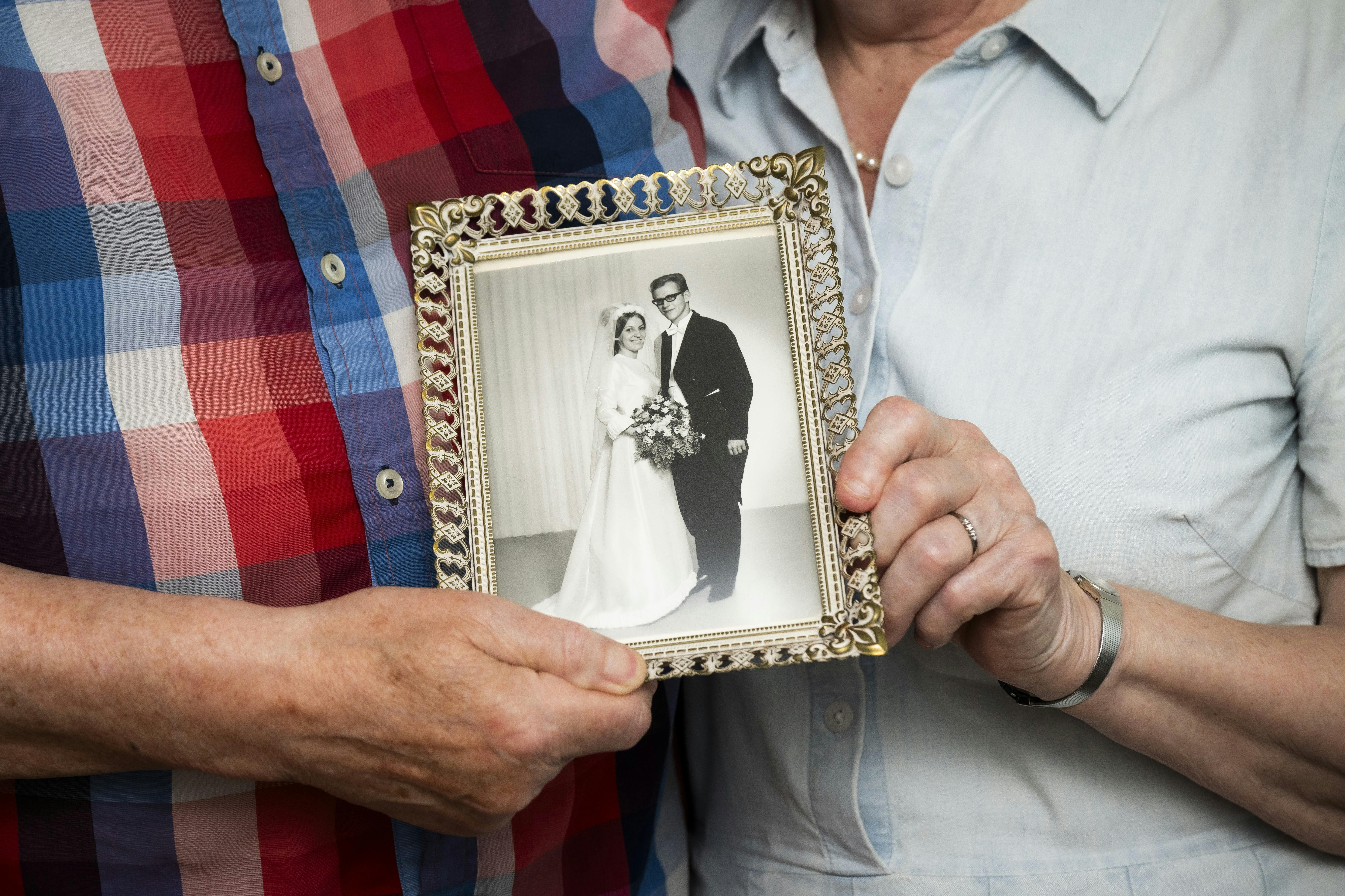 Britta og Svenning Ravn, der står med deres bryllupsbillede fra 1968.