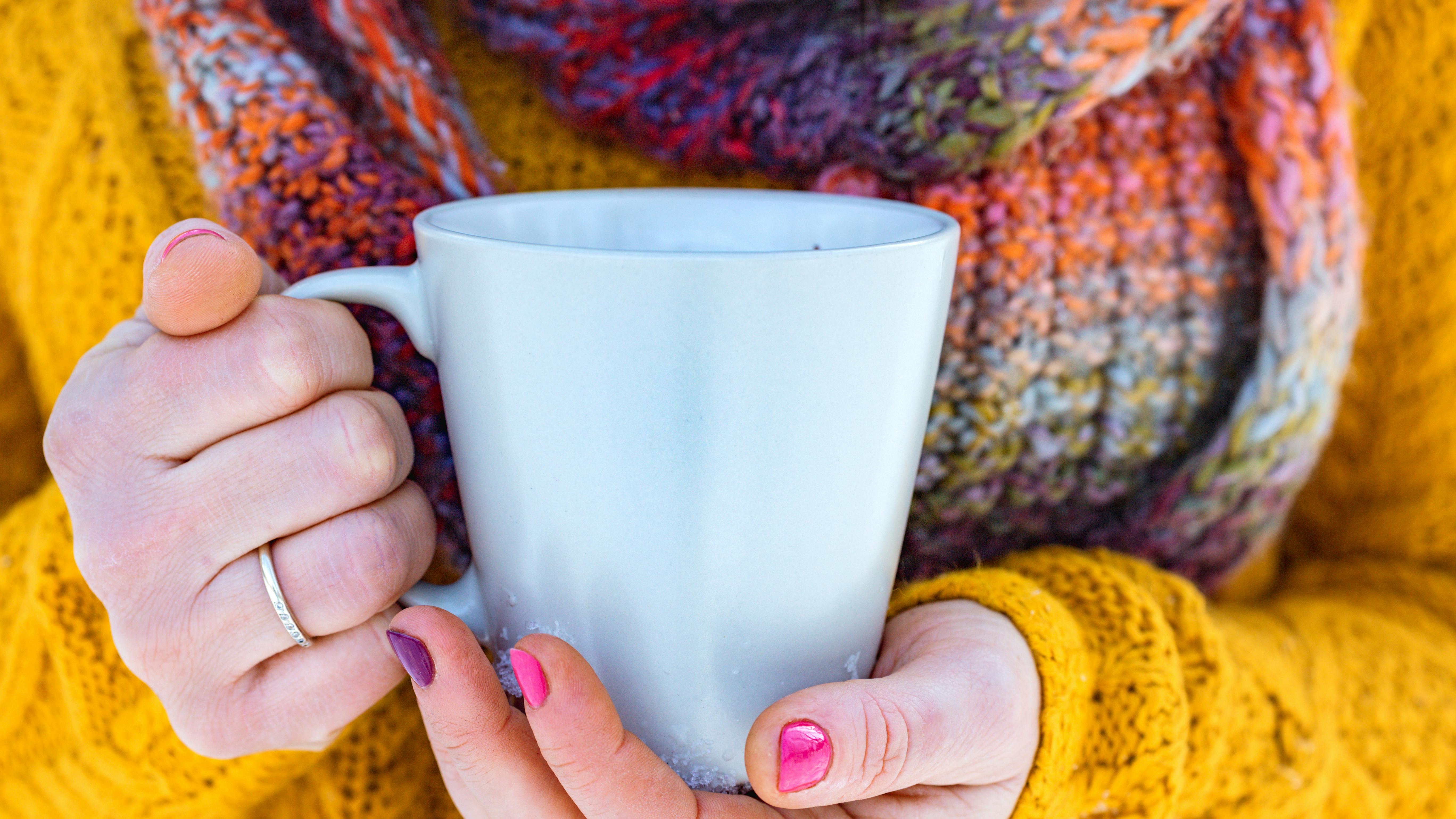 Kvinde der holder om en varm kop te